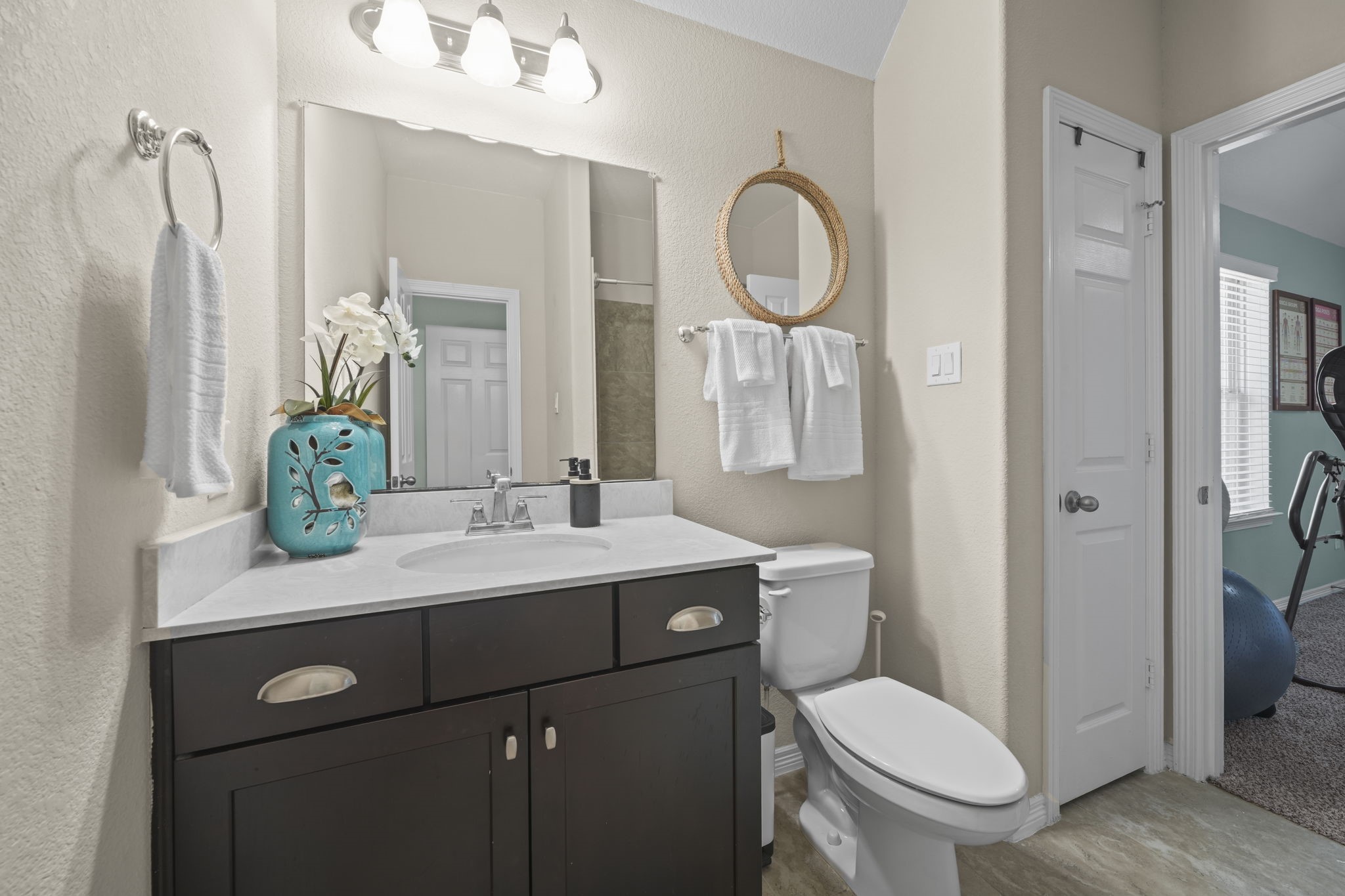 Charming bathroom featuring a sleek vanity with ample storage, stylish mirror accents, and a modern light fixture. The neutral tones create a calming atmosphere, complemented by tasteful decor.