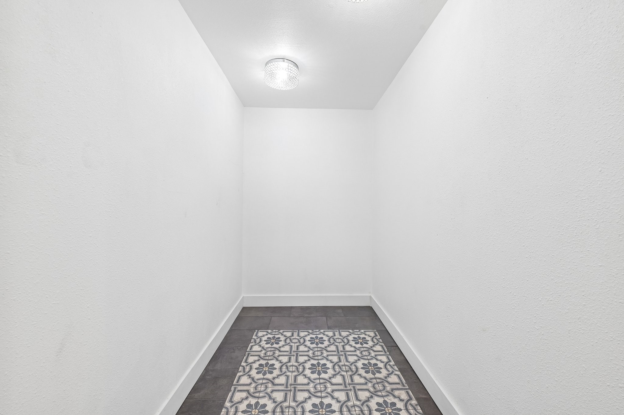 Huge walk-in primary closet with beautiful tile floor.