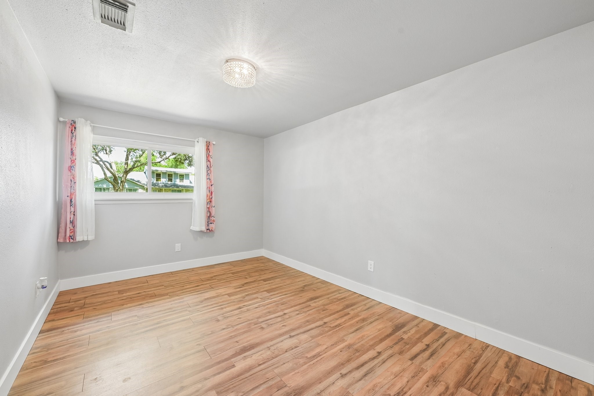 Large secondary bedroom with no carpet.