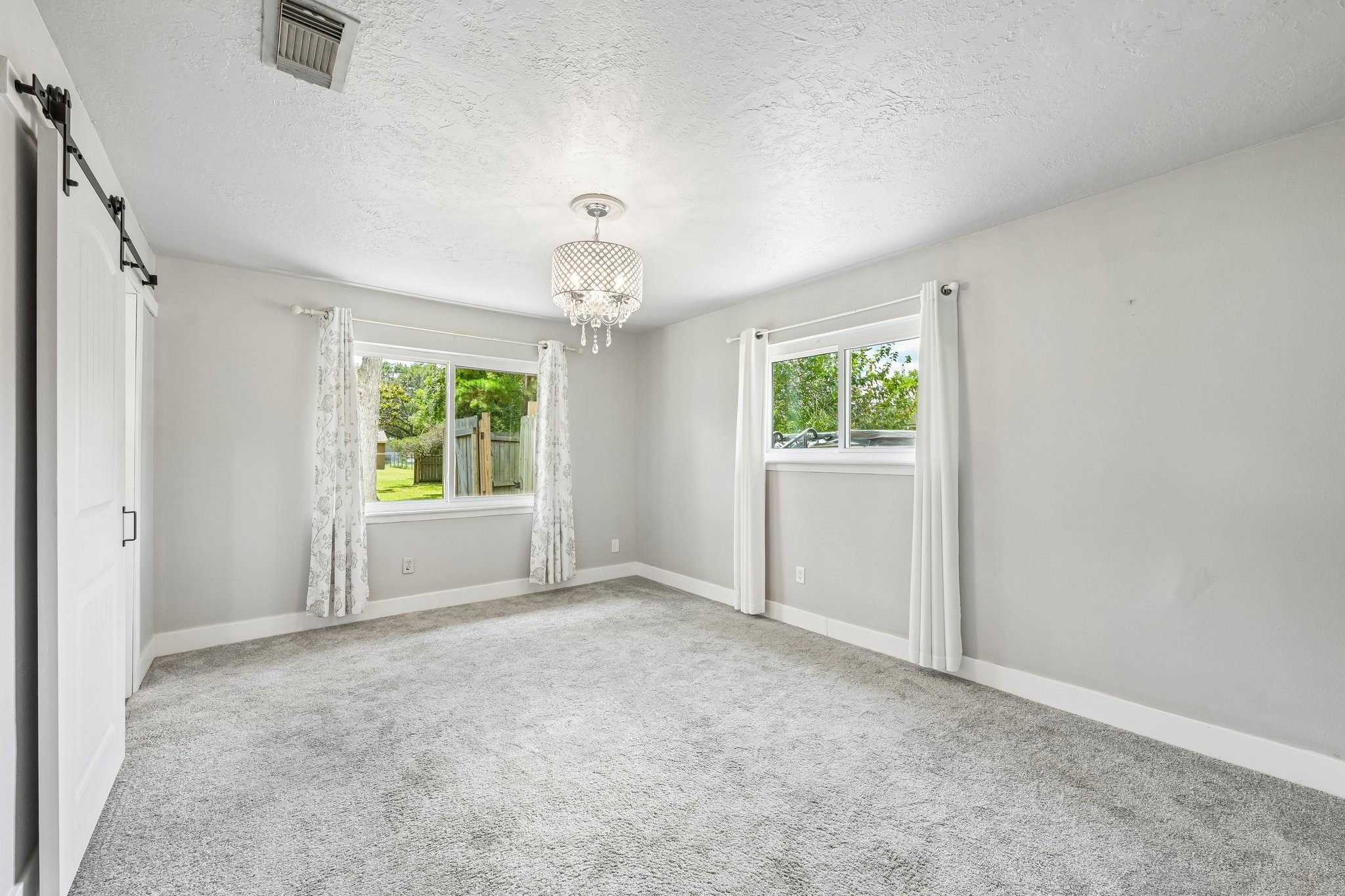 Beautiful primary bedroom overlooking the spa and backyard.