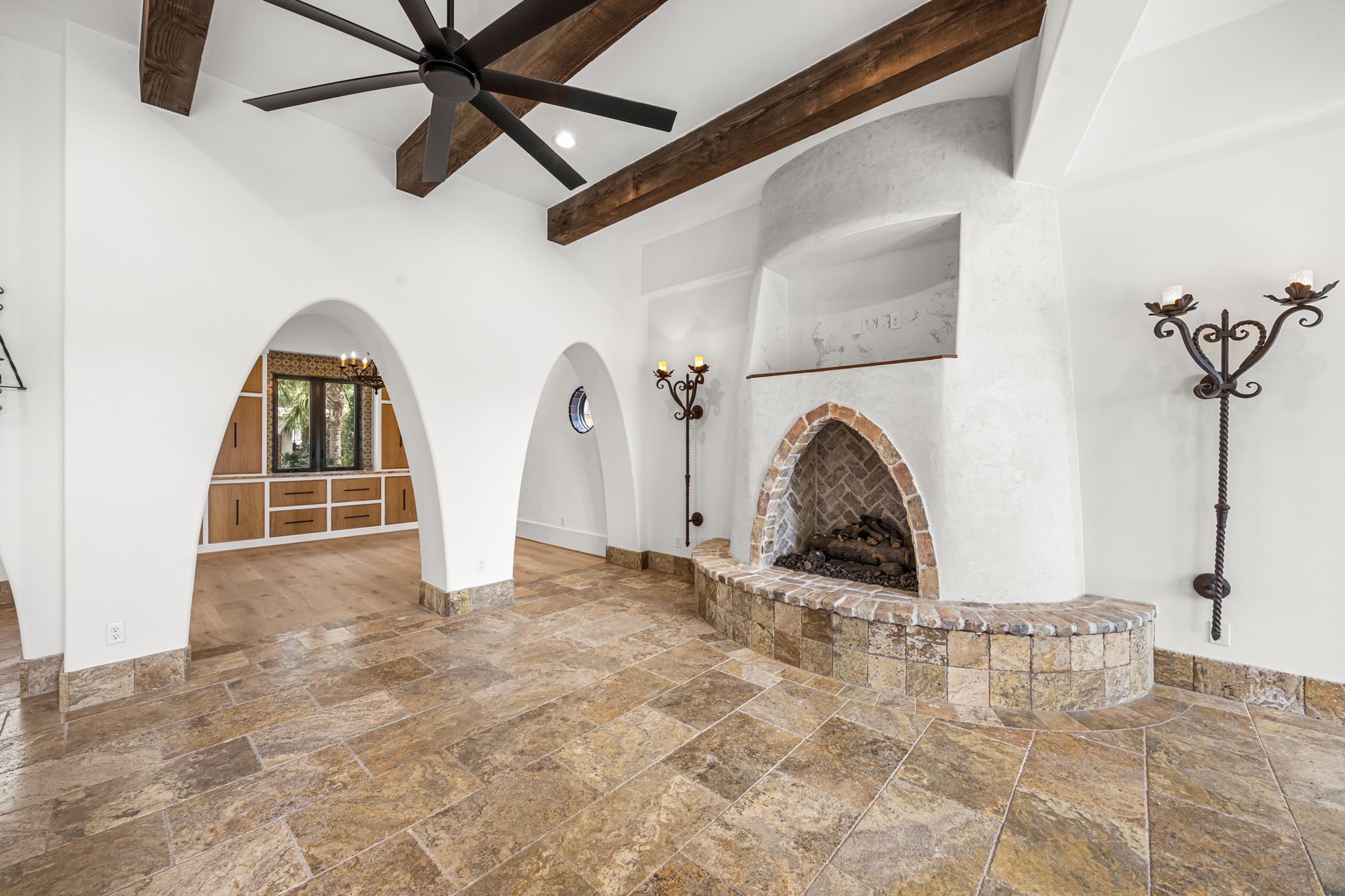 The living room offers a stunning perspective through a series of arched openings leading to the formal dining room, creating a seamless blend of sophistication and architectural charm.