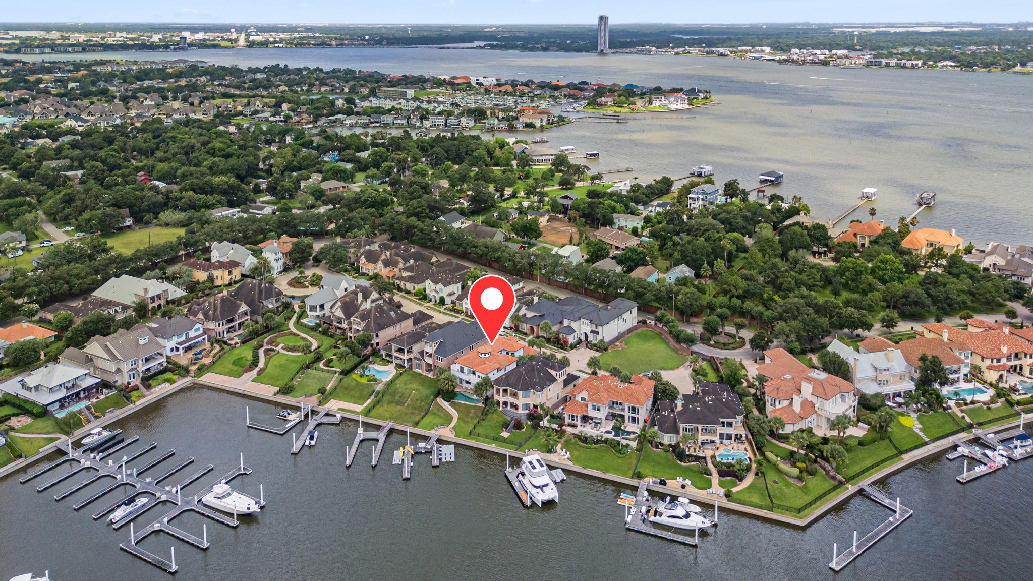 Aerial view of the home and marina highlights its exceptional waterfront setting, offering a more private and less congested location within the harbor.