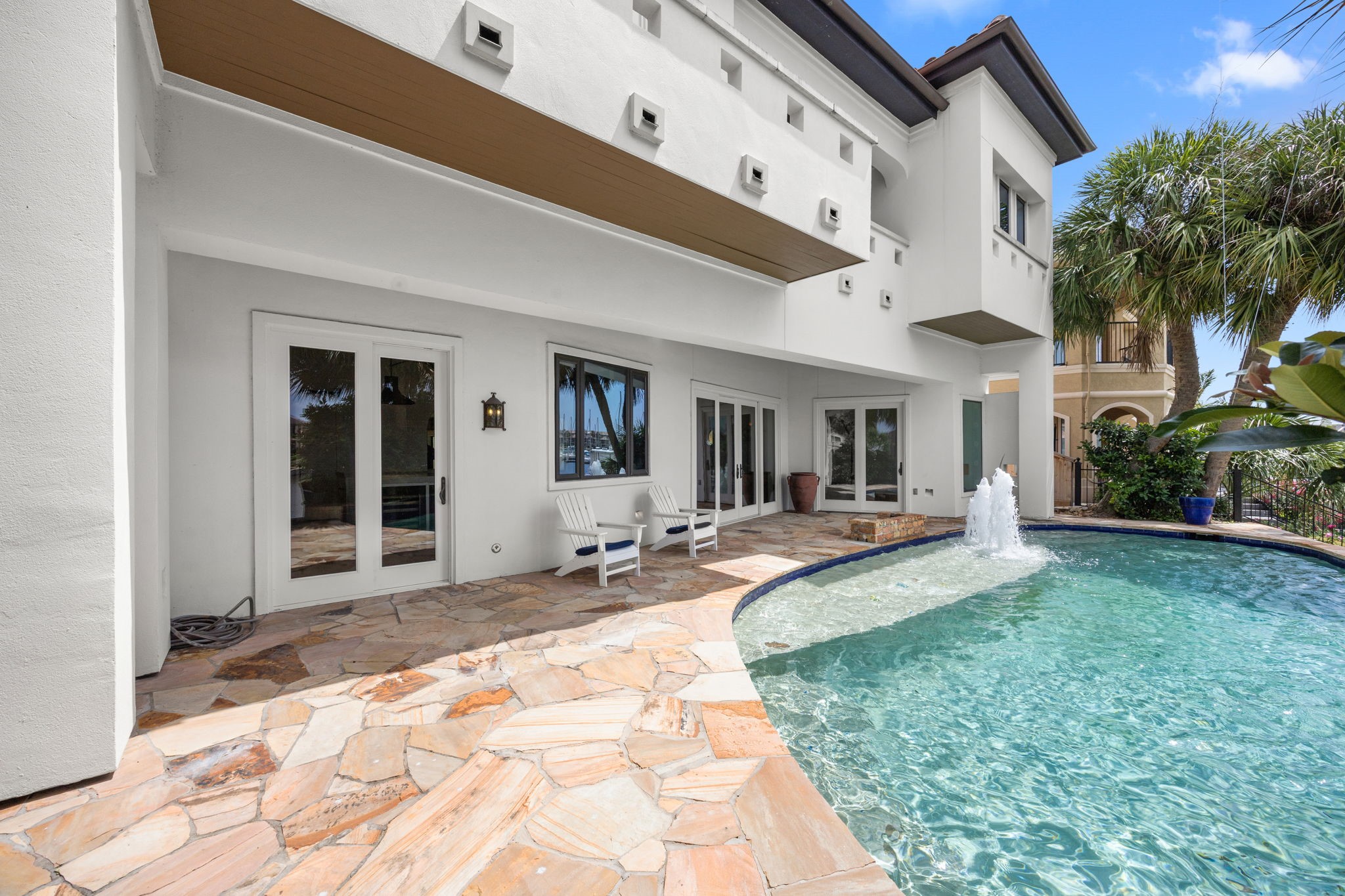 The resort-style pool is enhanced by grand fountains and a dramatic waterfall, creating a stunning backyard oasis.