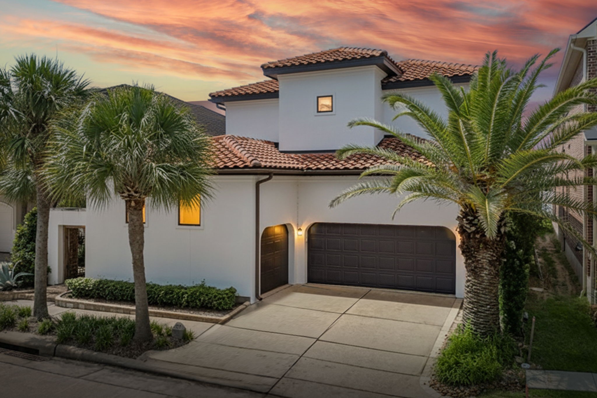 Mediterranean-style stucco home with a classic tile roof and a spacious three-car garage. Mediterranean-style stucco home with a classic tile roof and a spacious three-car garage.
