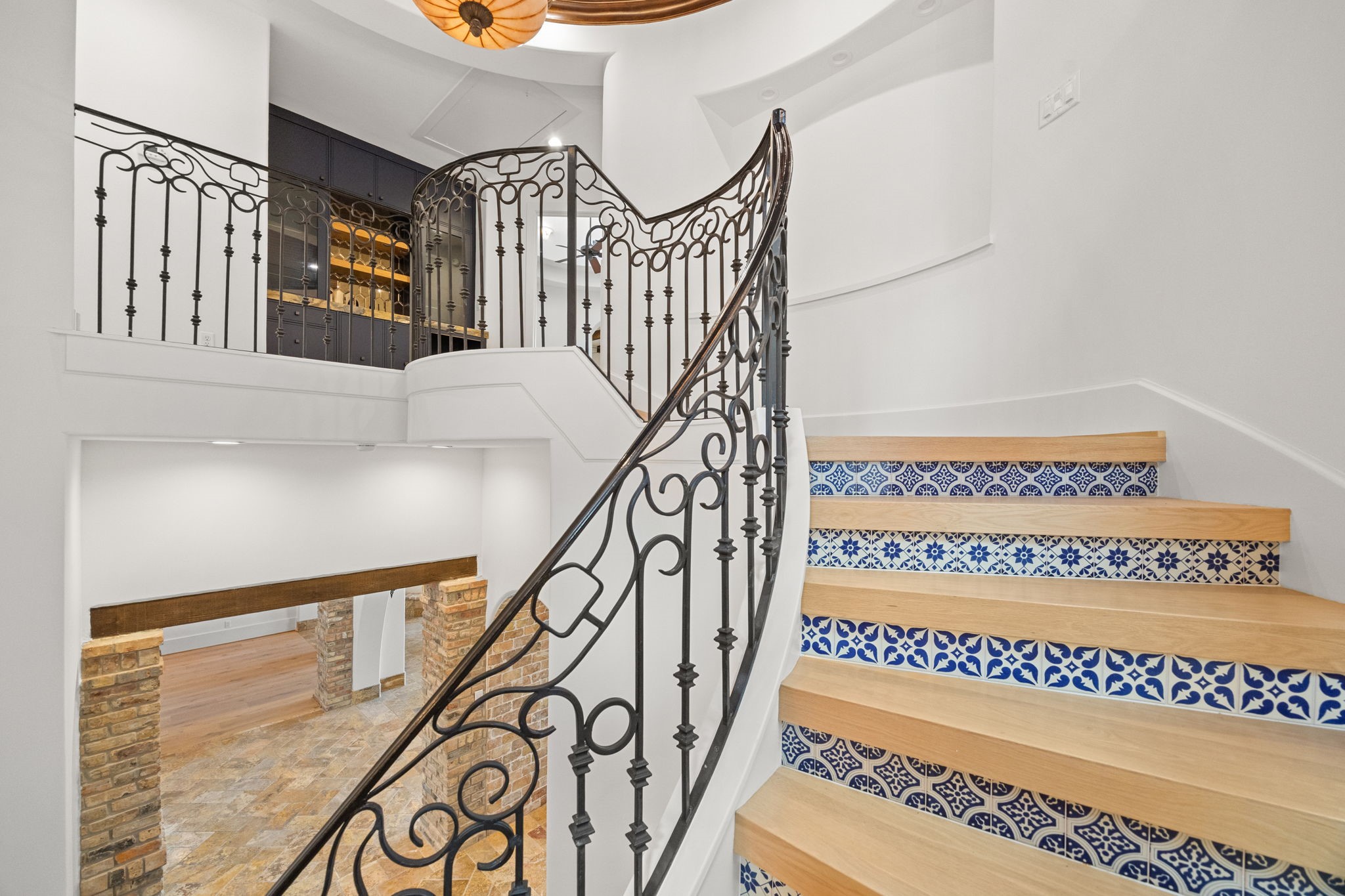 Another view of the grand staircase reveals its elegant ascent to the second level, where a stylish wet bar enhances the home's entertaining spaces.