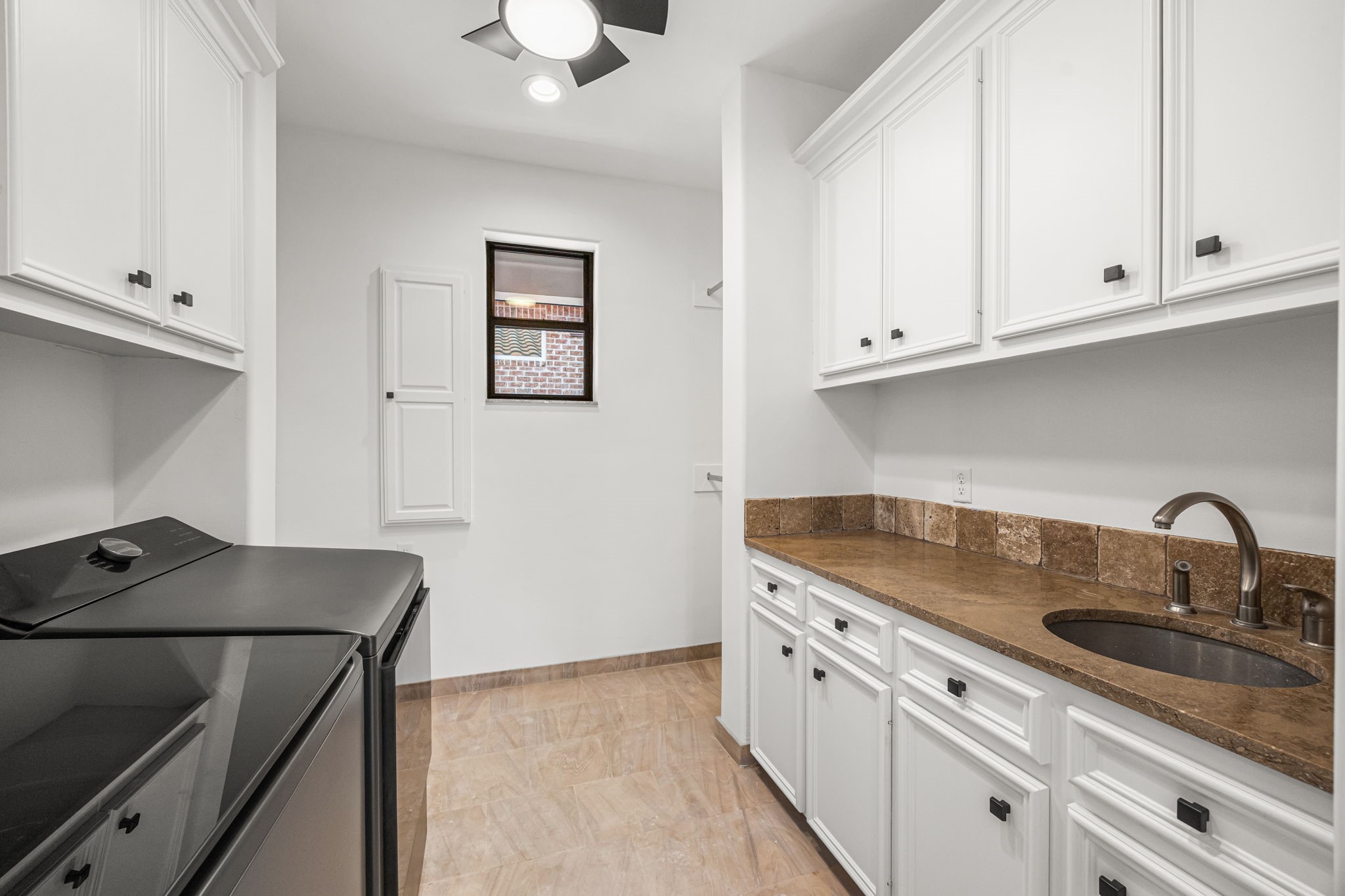 The upstairs laundry room is thoughtfully designed with custom cabinetry, clothing rods, and an extra-large closet for added convenience and storage.