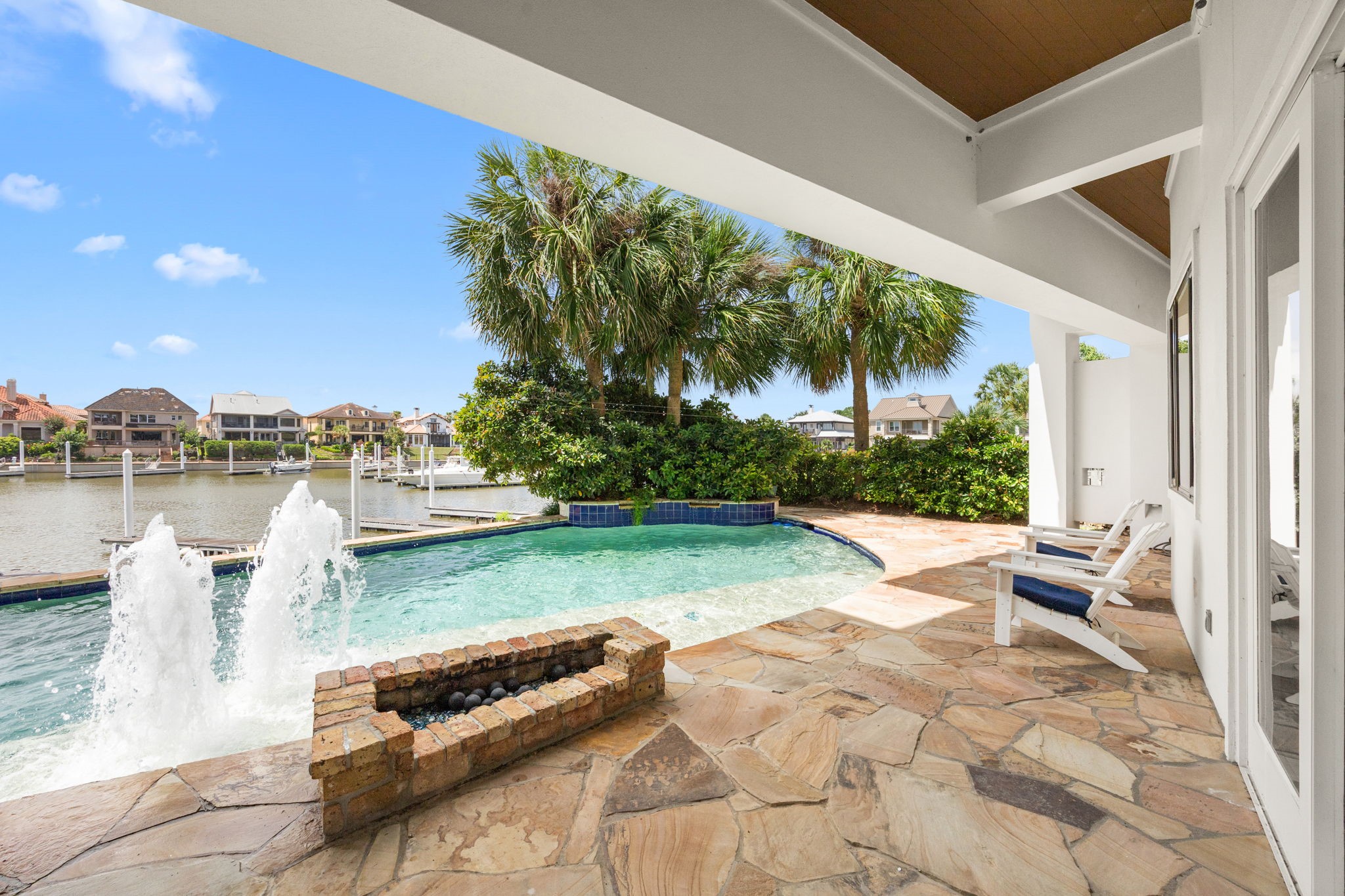 The resort-style pool is enhanced by grand fountains and a dramatic waterfall, creating a stunning backyard oasis.