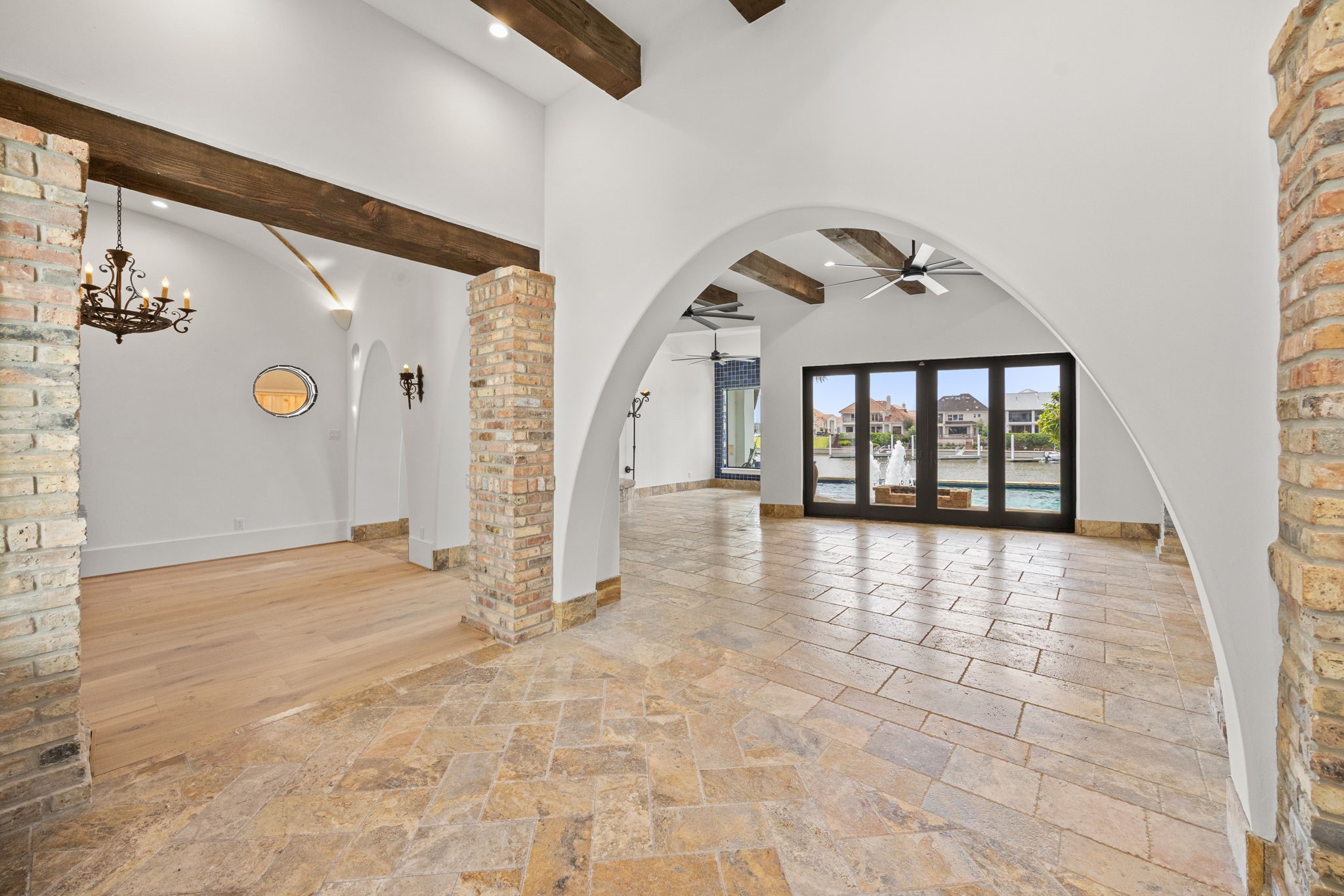 The formal entry is enhanced by rich brick accents and a soaring ceiling, offering stunning sightlines that extend through the home to the pool and marina beyond. The formal entry is enhanced by rich brick accents and a soaring ceiling, offering stunning sightlines that extend through the home to the pool and marina beyond.