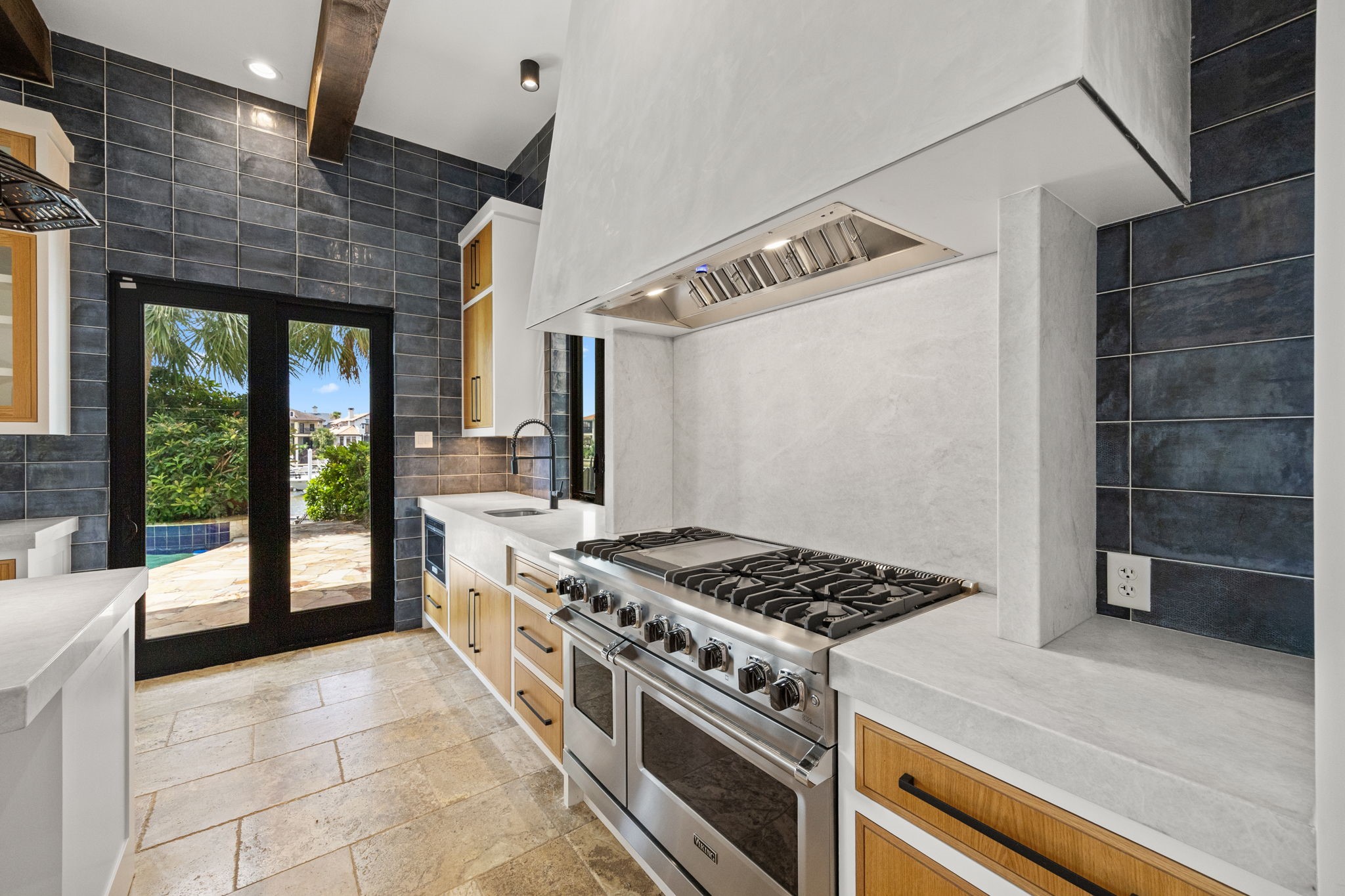 An additional view of the professional Viking range highlights the richly detailed accent wall, showcasing layered textures and refined finishes that elevate the kitchens dramatic focal point.
