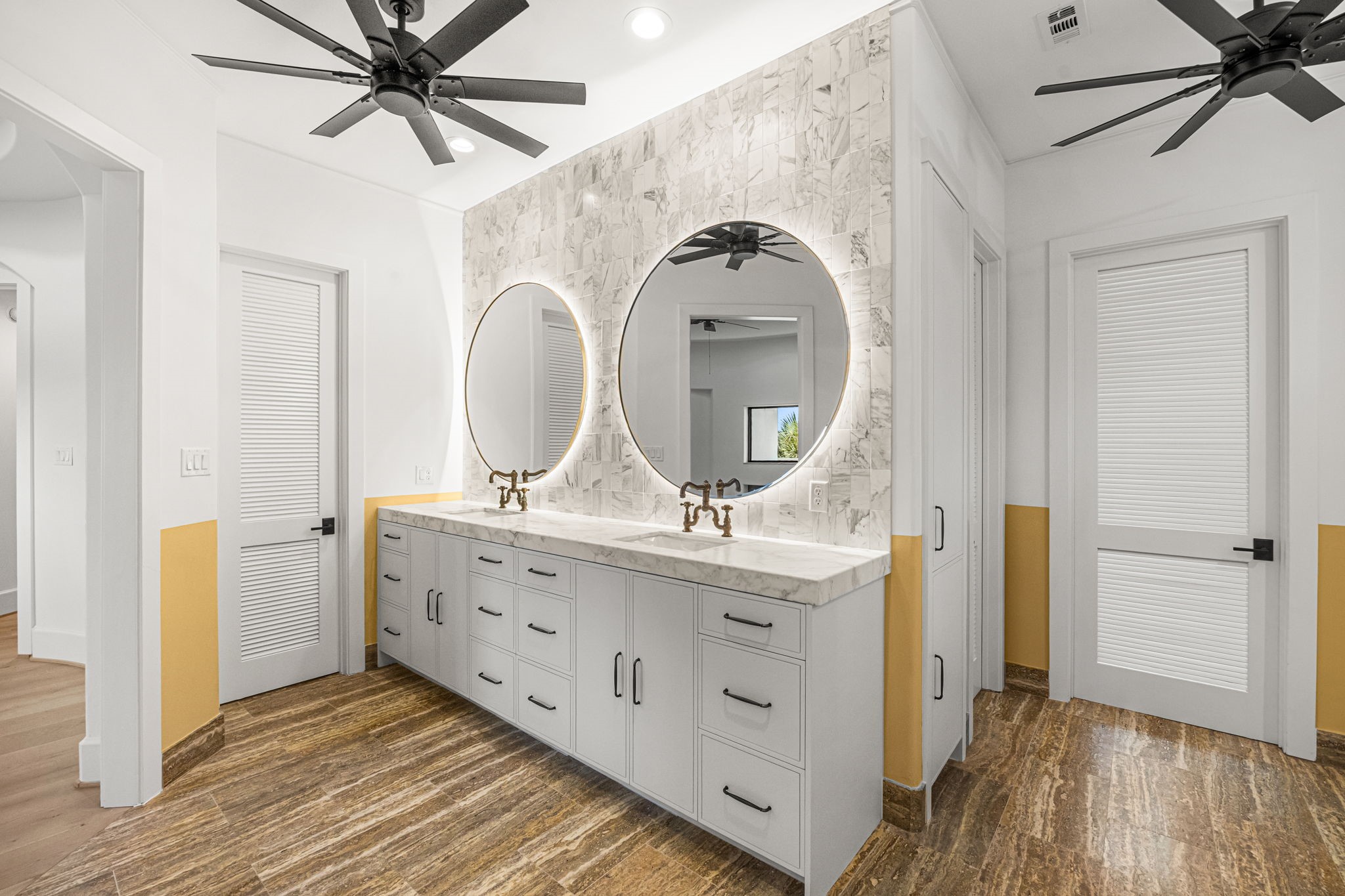 The upstairs primary bath features dual sinks and elegant backlit mirrors, creating a modern and sophisticated vanity space. The bathroom also includes two private water closets, one of which is thoughtfully equipped with a bidet for added comfort and convenience.