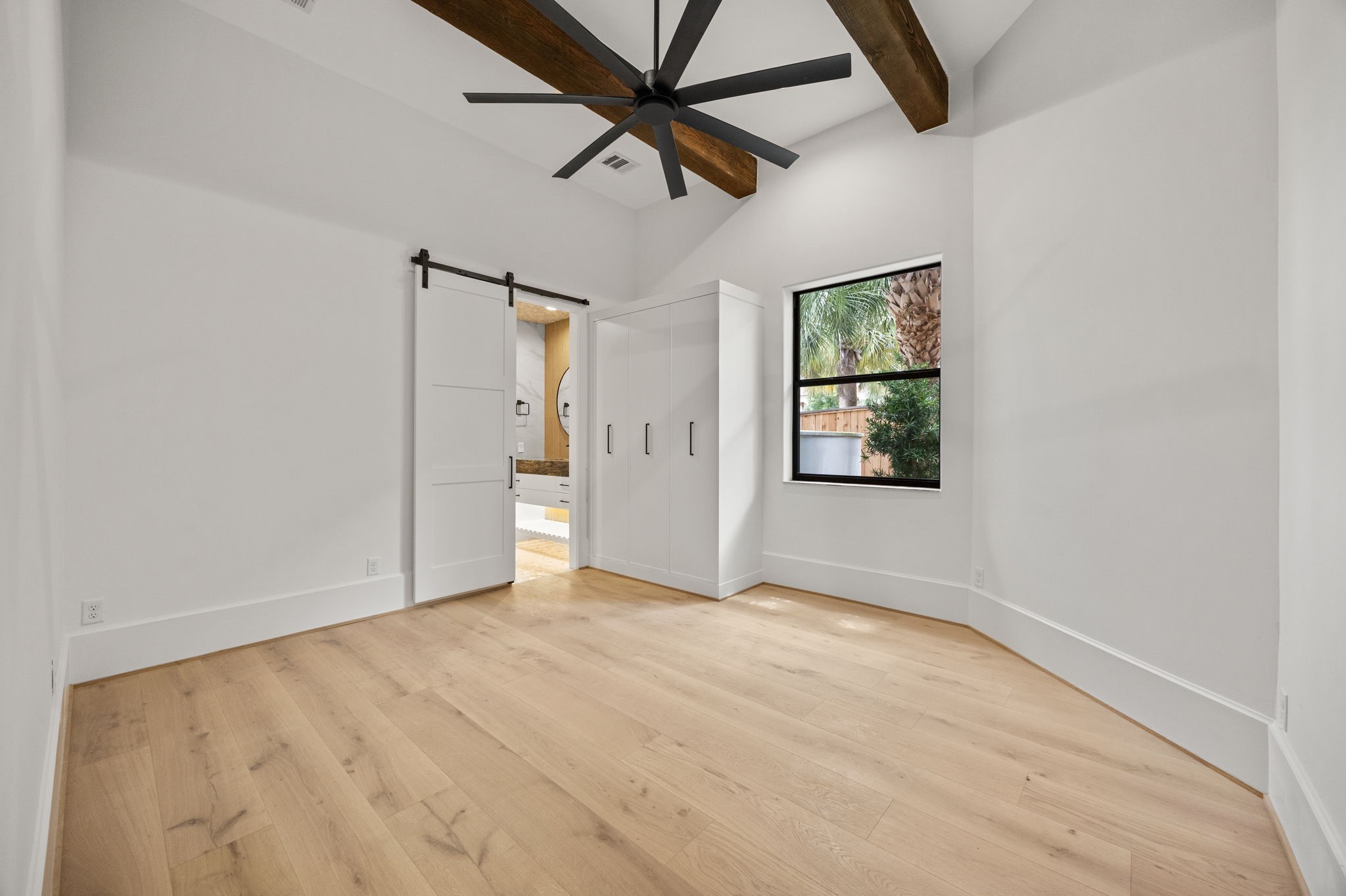 The downstairs primary suite features custom built-in wardrobe cabinetry, offering refined storage and elegant organization.
