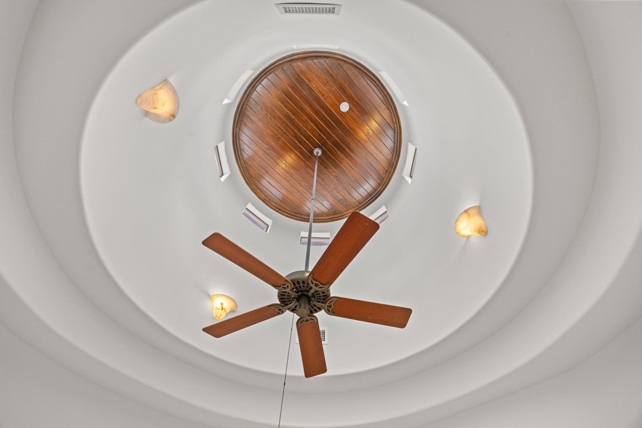 Above the staircase, a beautifully crafted rotunda ceiling adds height, drama, and timeless architectural elegance.