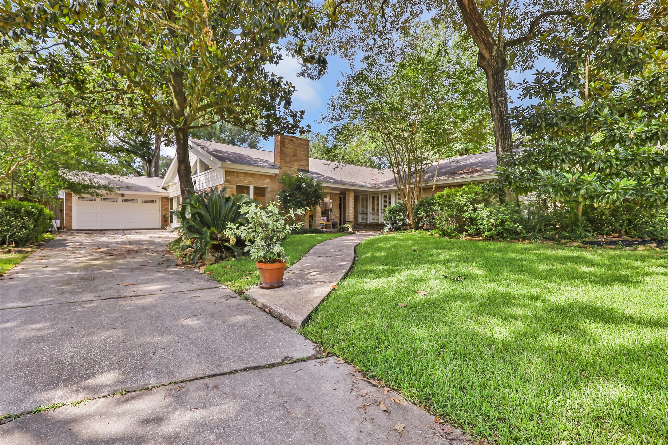 Charming single-story home nestled among mature trees, featuring a spacious front yard with lush greenery and a winding path leading to the inviting entrance. Charming single-story home nestled among mature trees, featuring a spacious front yard with lush greenery and a winding path leading to the inviting entrance.