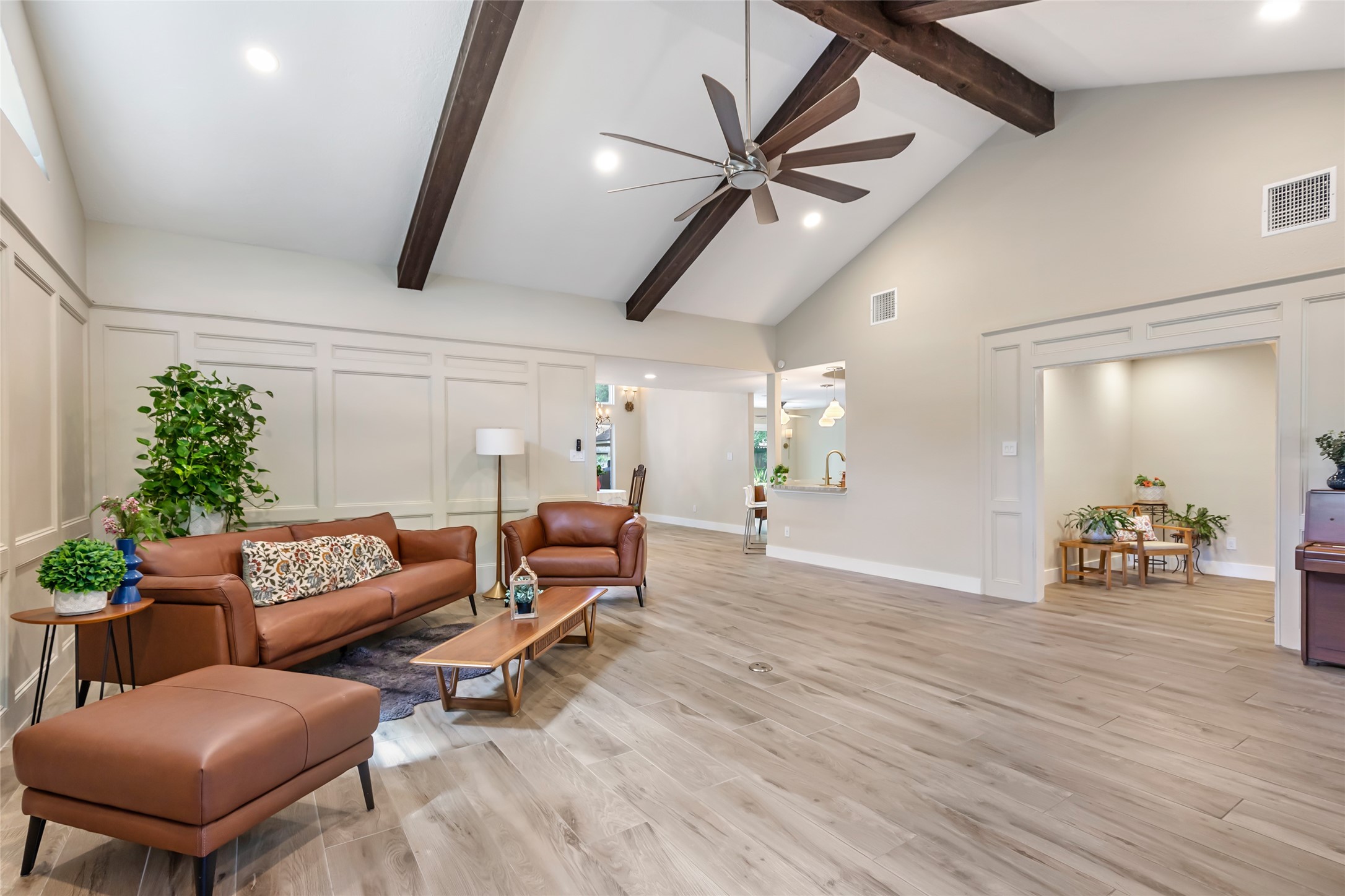 Spacious living area with vaulted ceilings, exposed beams, and elegant and durable ceramic wood flooring. Spacious living area with vaulted ceilings, exposed beams, and elegant and durable ceramic wood flooring.