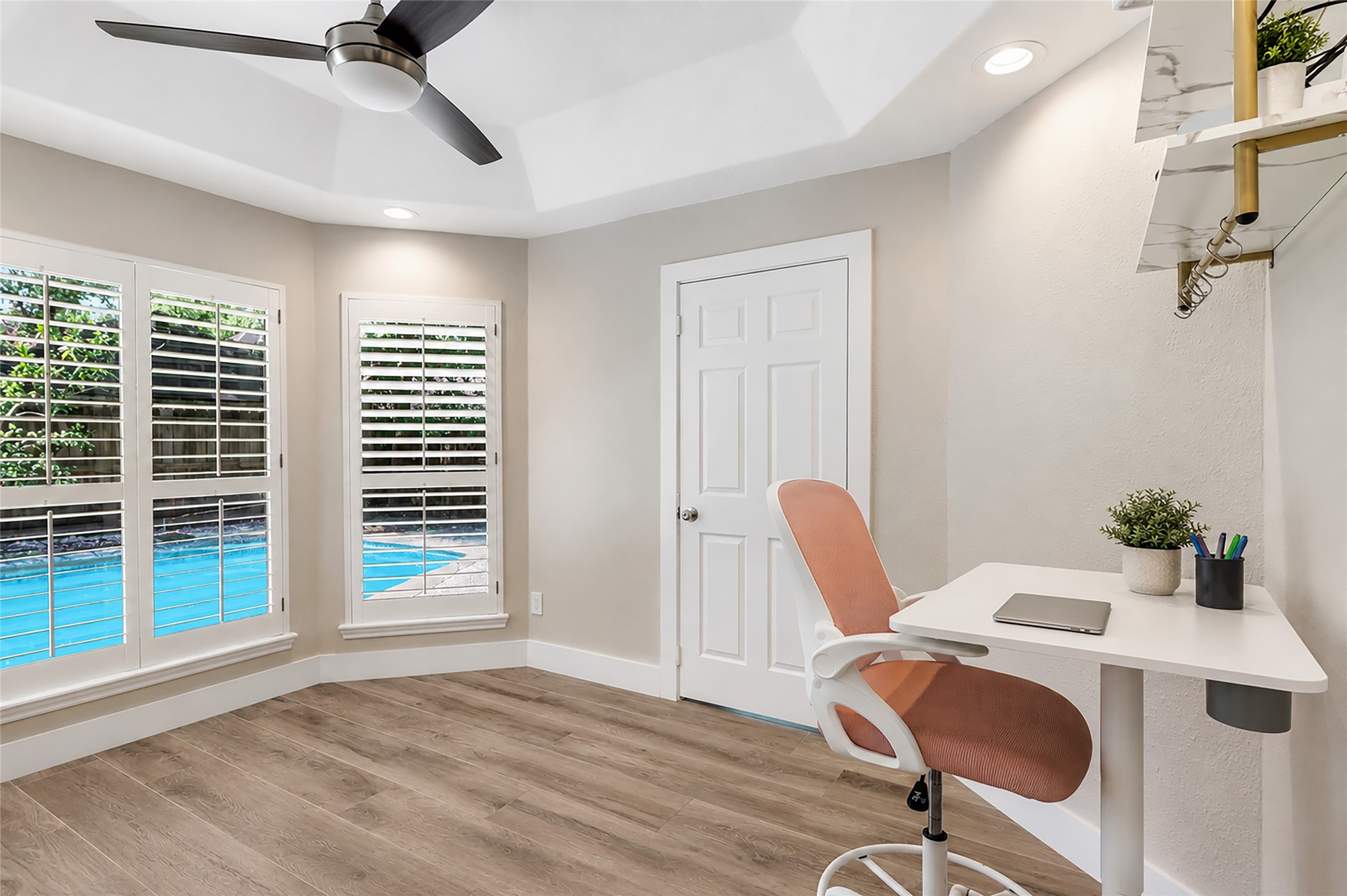 Bright home office/home/gym gym/nursery with pool views, featuring large windows with shutters, would also make for a great nursery or home gym!