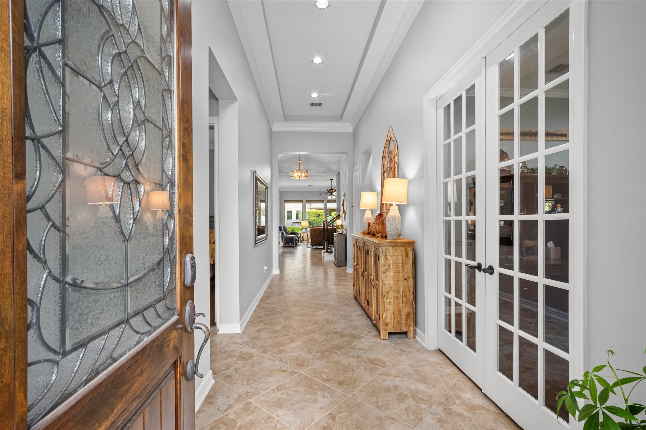 Welcome!  Home office/study just inside to the right behind the french doors. Wide entryway then leads to the open living/kitchen/breakfast space that overlooks the backyard.