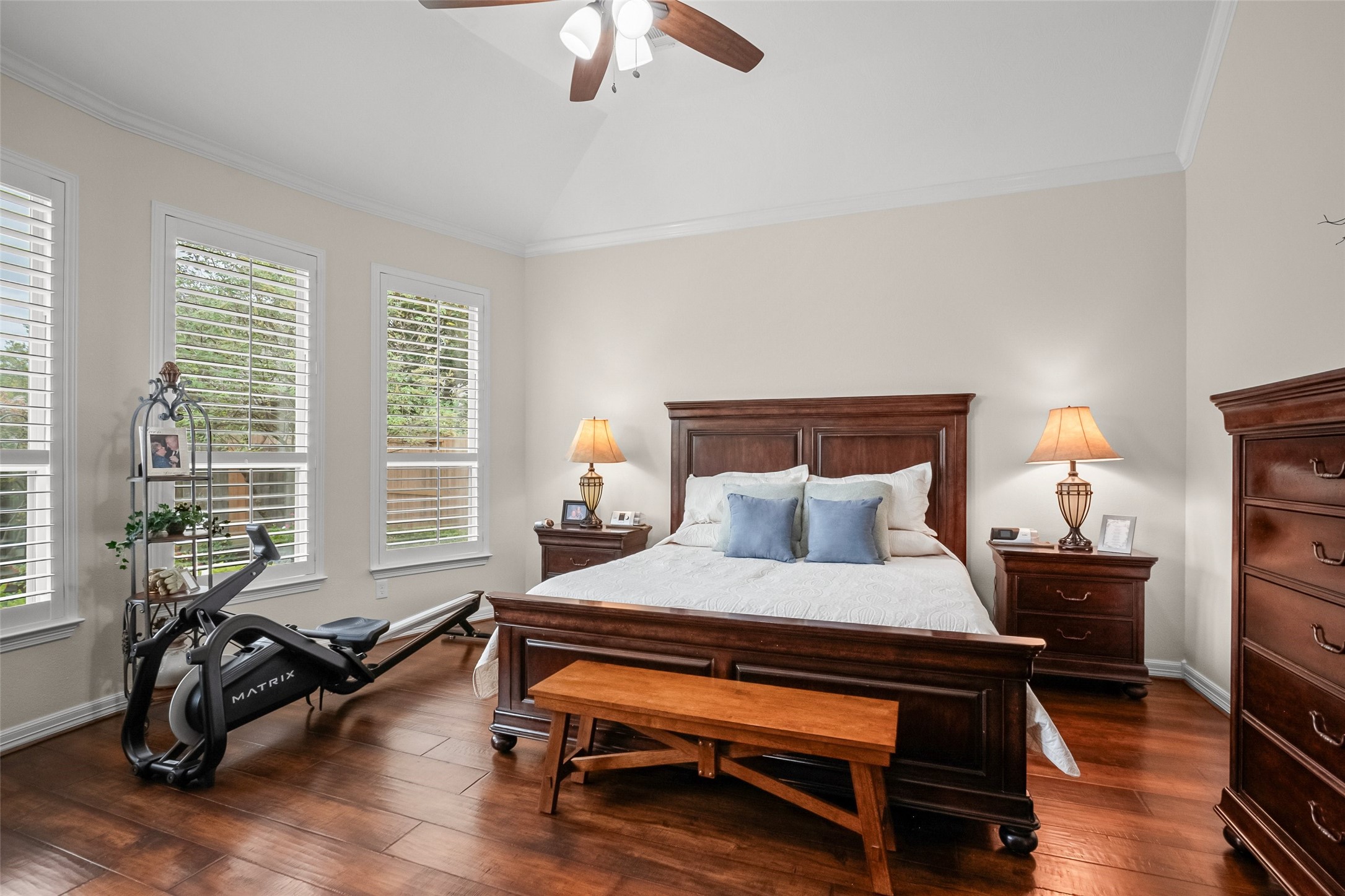 Large primary bedroom with numerous windows overlooking the backyard.