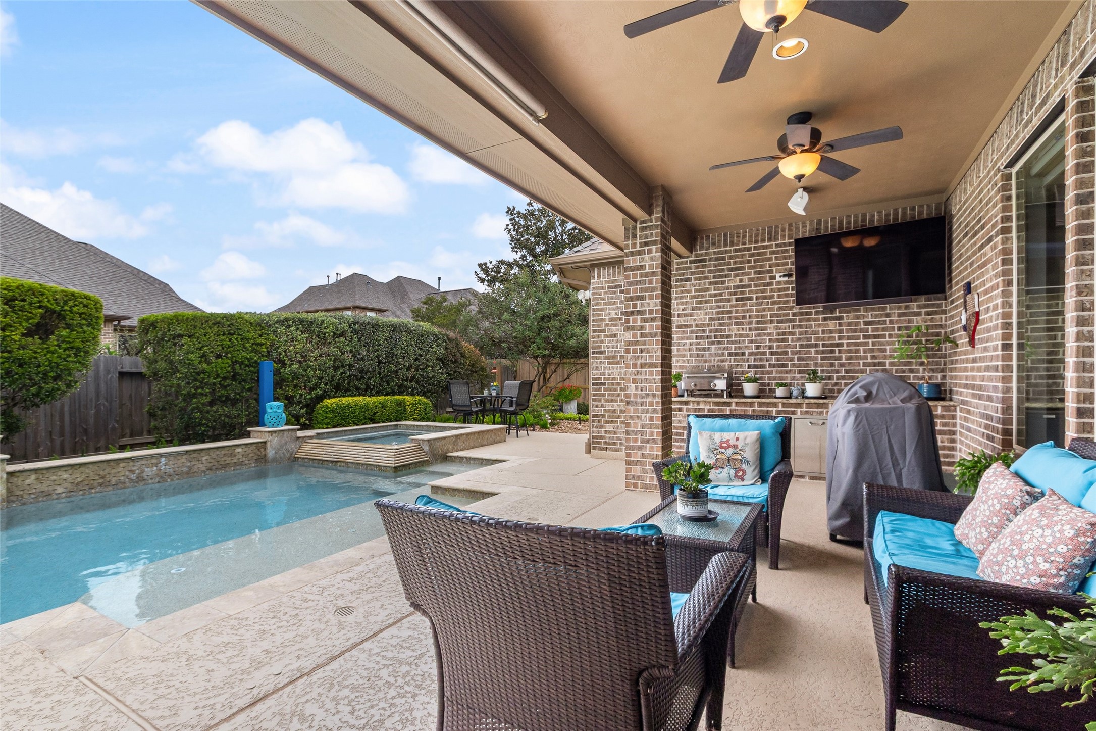 Watch the swimmers from the patio, or enjoy a visit with family & friends.  This covered patio has a counter for a tabletop grill & a built-in refrigerator.  This would be a great spot for a tabletop griddle as well.  (The small grill seen in pic isn't built-in, and doesn't stay with the home).