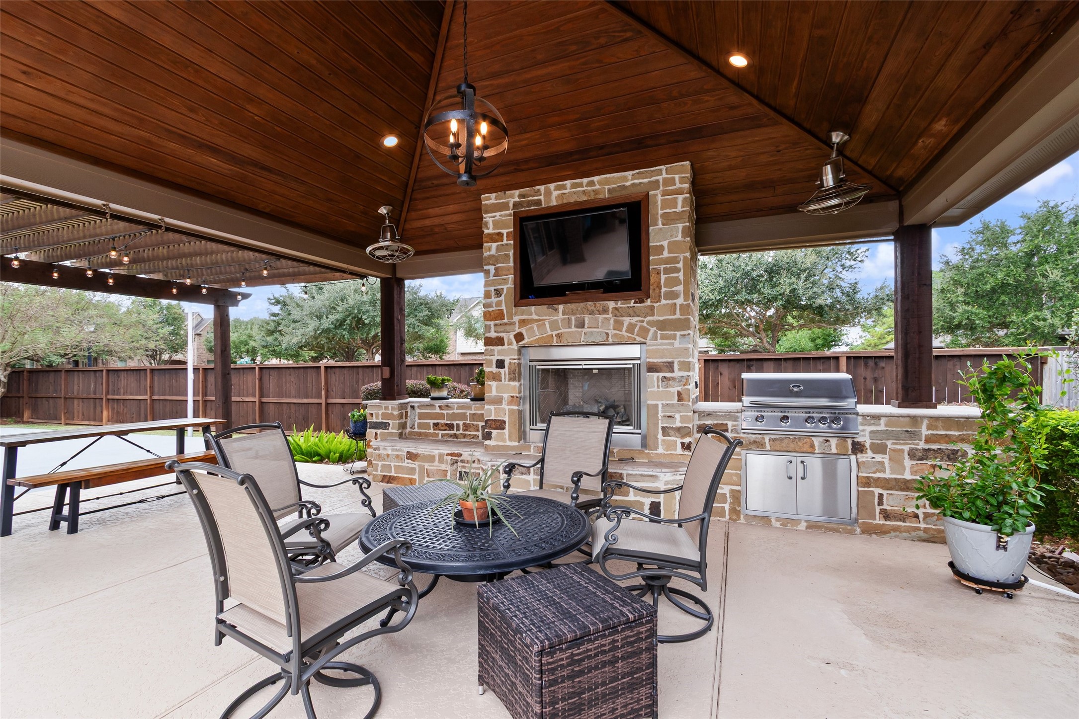 Another look at the covered pergola with outdoor lighting/fan, and a better look at the gas grill and prep space.  On the other side of the long table/bench is the beginning of the sport court.  There is something for everyone right in your own backyard.