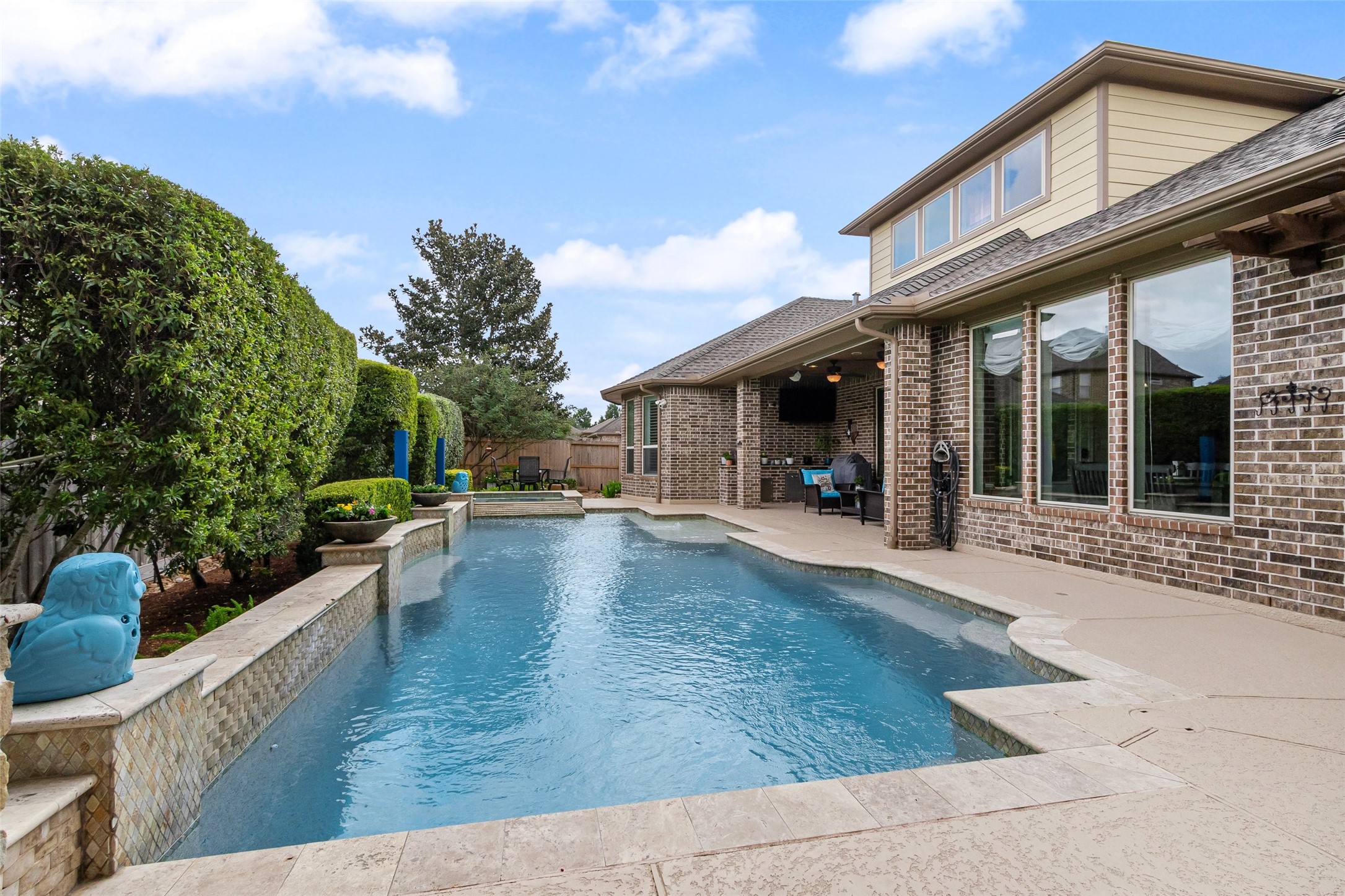 Looking across the pool/spa from the other direction.  Notice the natural looking stone that surrounds the pool and graces the short wall behind the pool. The location of the covered patio can be seen here.