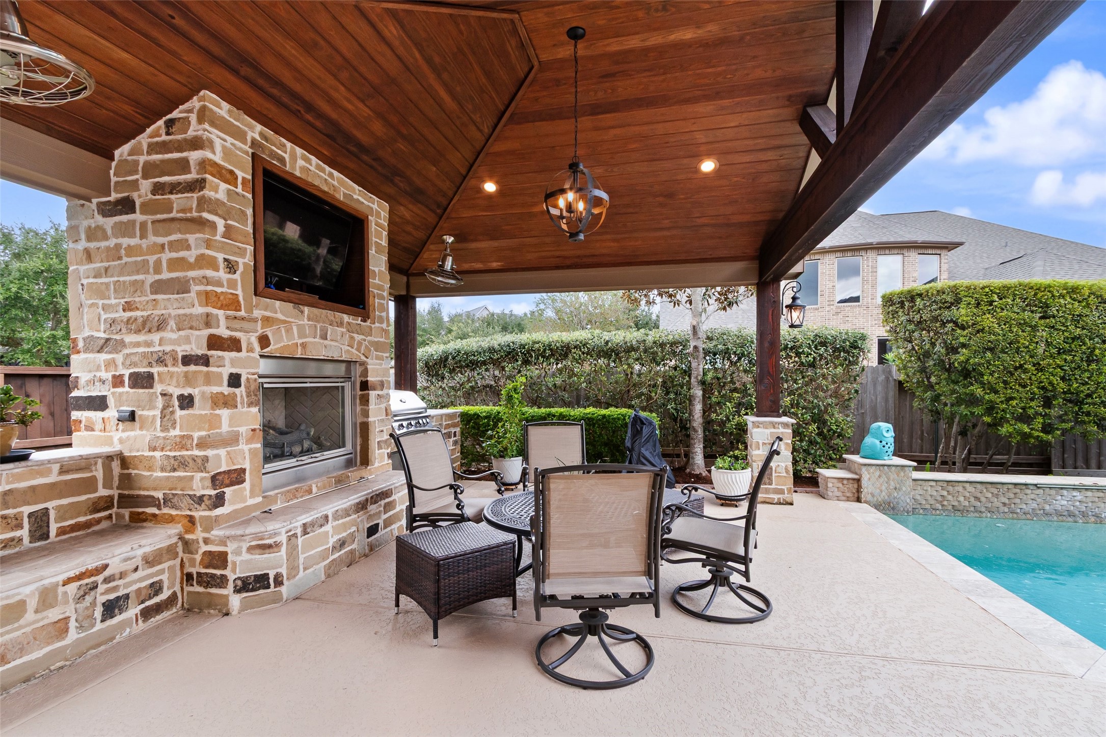Pergola fully covered with a gas log fireplace & outdoor kitchen that includes a built-in gas grill.  Gather around the fireplace for a football game or cook a meal while swimming in the summertime.  This outdoor space flows seamlessly between the seasons.