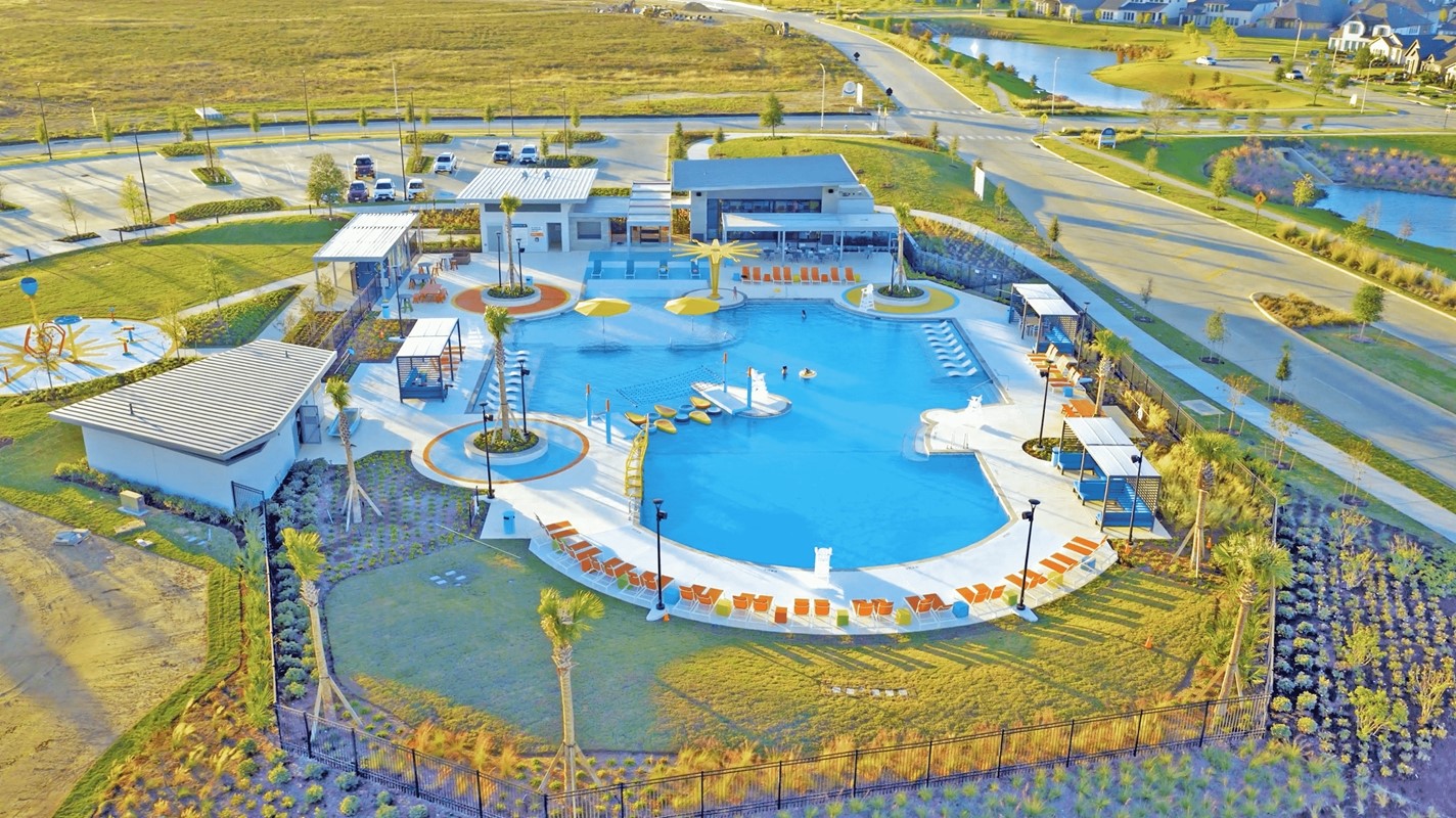 Experience resort-style living with this expansive community pool area, featuring modern amenities, ample lounge seating, and beautifully landscaped surroundings perfect for relaxation and recreation.