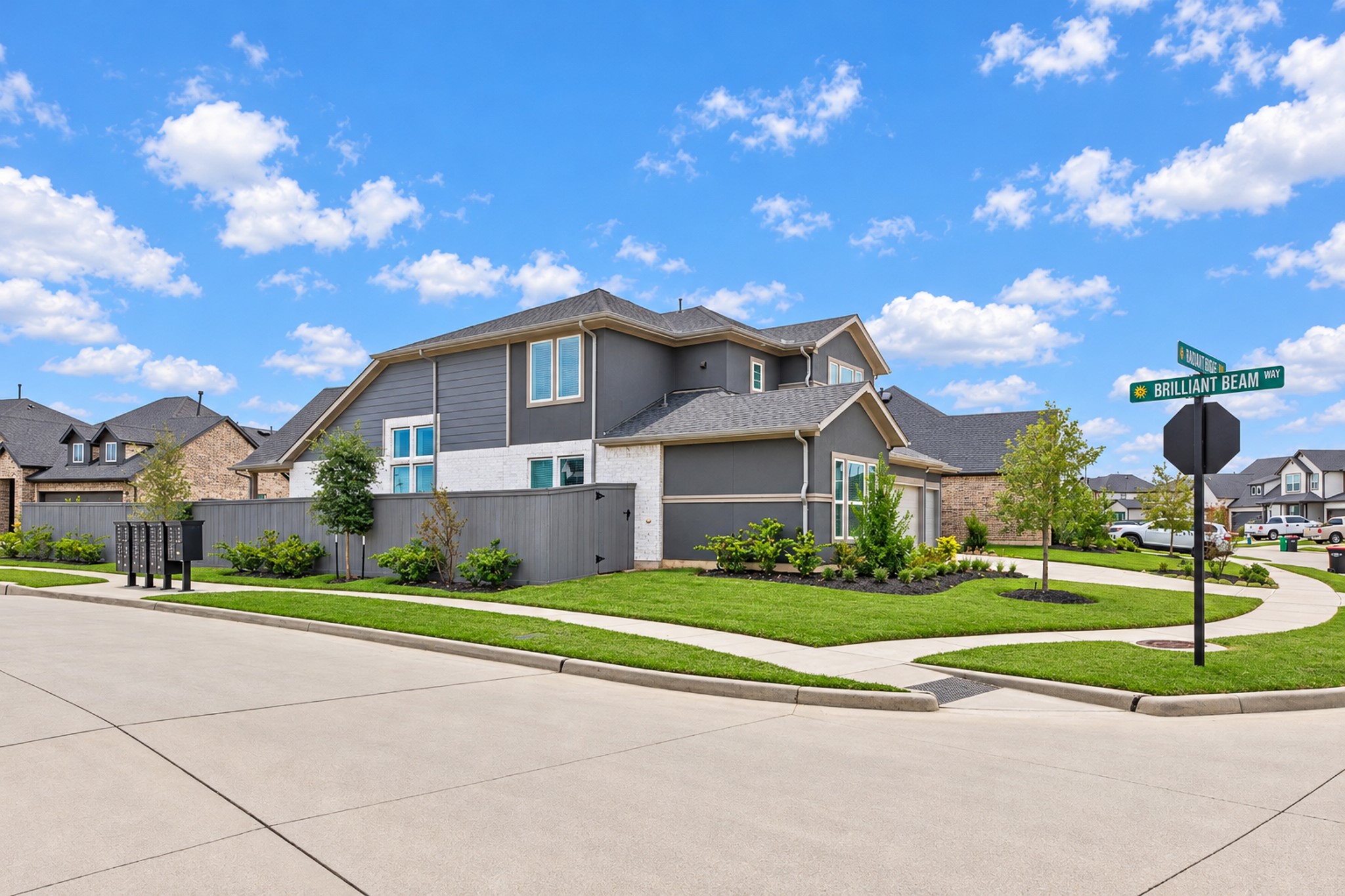 Stylish modern home on a corner lot with lush landscaping, spacious sidewalks, and a striking exterior in a well-maintained neighborhood.