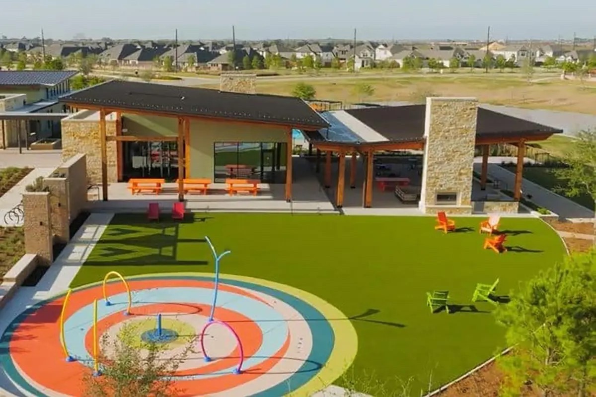 Charming community center featuring a modern pavilion, vibrant splash pad, and inviting outdoor seating, perfect for family gatherings and relaxation.
