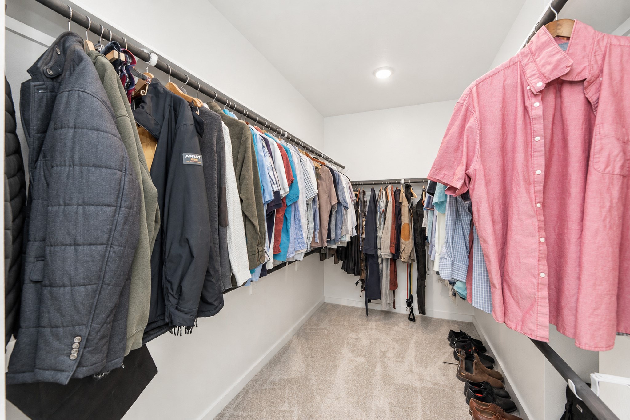 Spacious walk-in closet with ample hanging space and neatly organized shelving, perfect for all your wardrobe needs.
