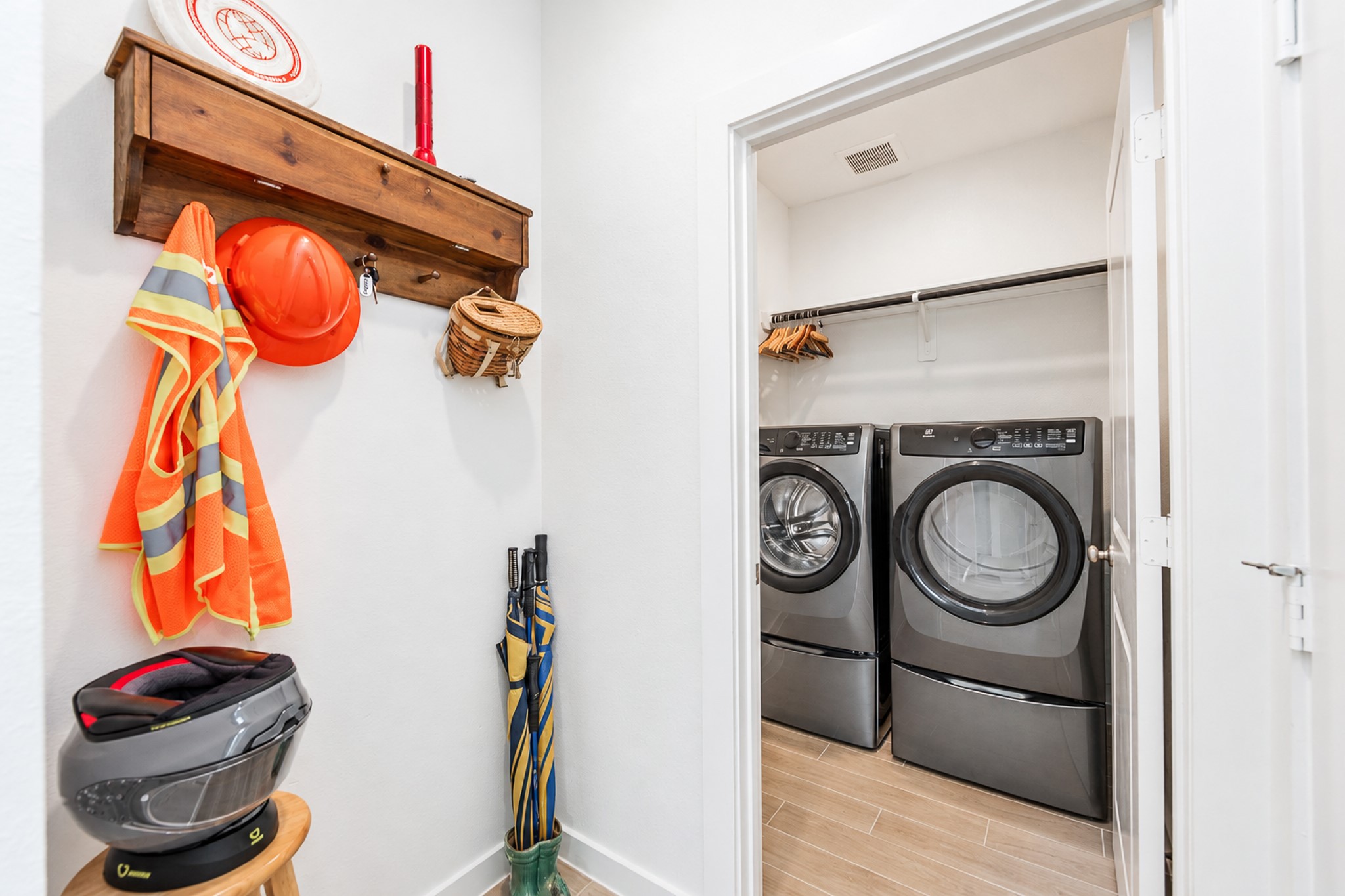 Conveniently designed laundry area with modern washer and dryer, ample storage, and space for organizing outerwear and accessories.