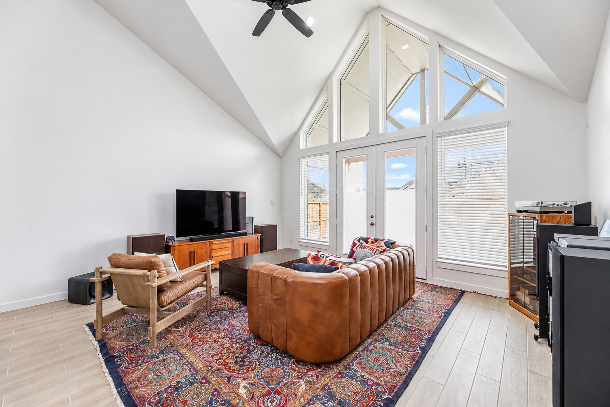 Bright and inviting living space featuring vaulted ceilings, expansive windows, and modern furnishings, creating a perfect blend of comfort and style.