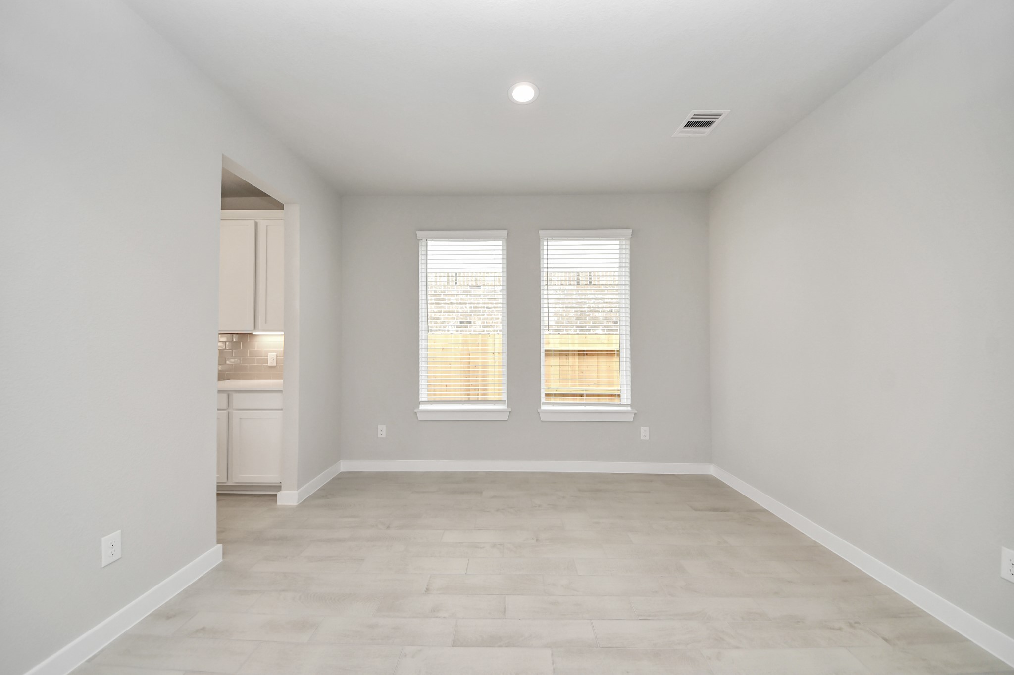 Create lasting memories with your family and friends at the dining table! This expansive dining room showcases sophisticated flooring, custom paint, and seamlessly connects to the family room and kitchen, providing an open and inviting atmosphere. Sample photo of completed home with similar floor plan. Actual colors and selections may vary.