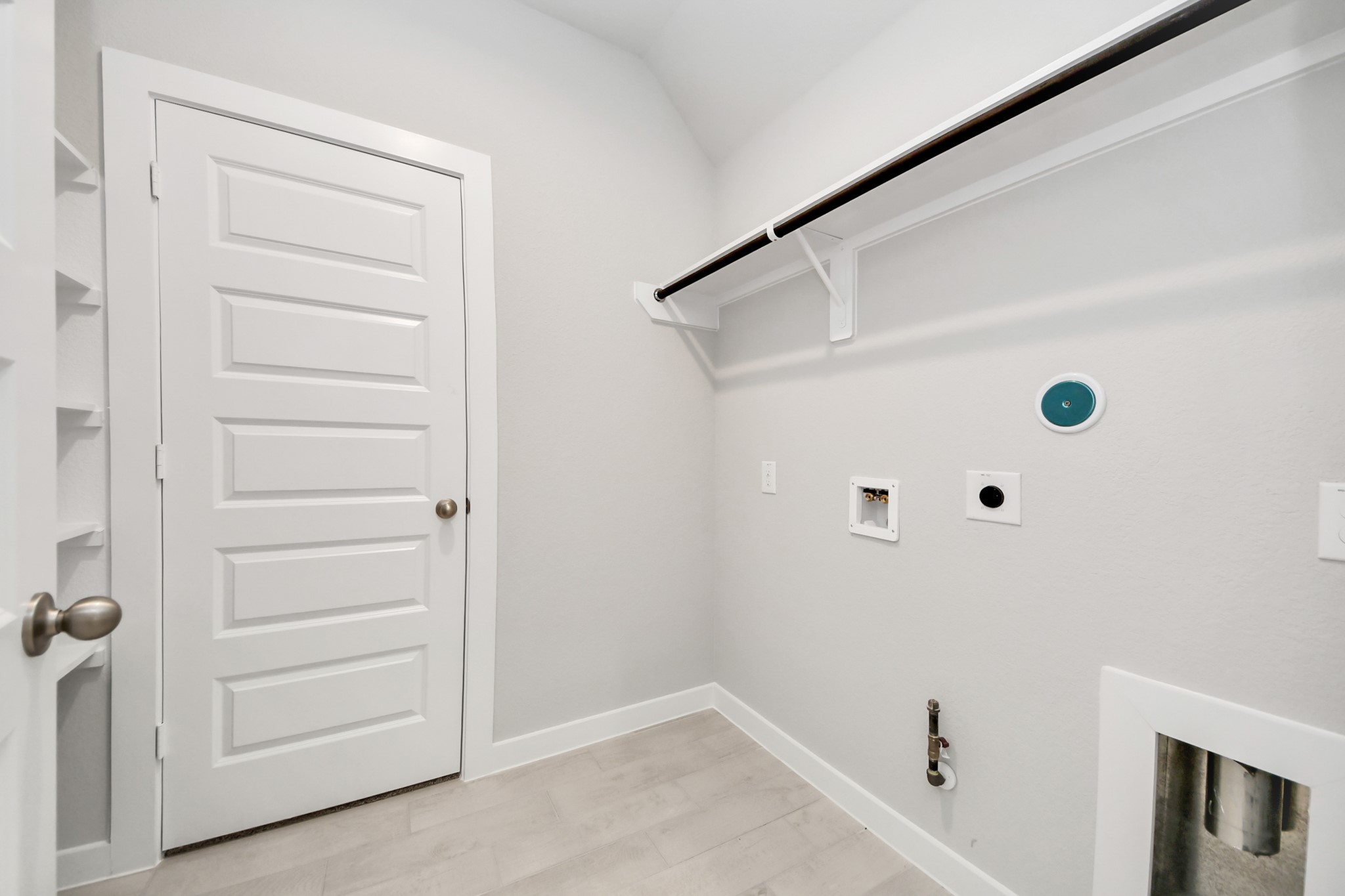 A perfect blend of functionality and comfort. Capture the essence of easy living with a first-floor laundry room, thoughtfully equipped with shelving for effortless organization. Both electric and gas connections available. Sample photo of completed home with similar floor plan. Actual colors and selections may vary.
