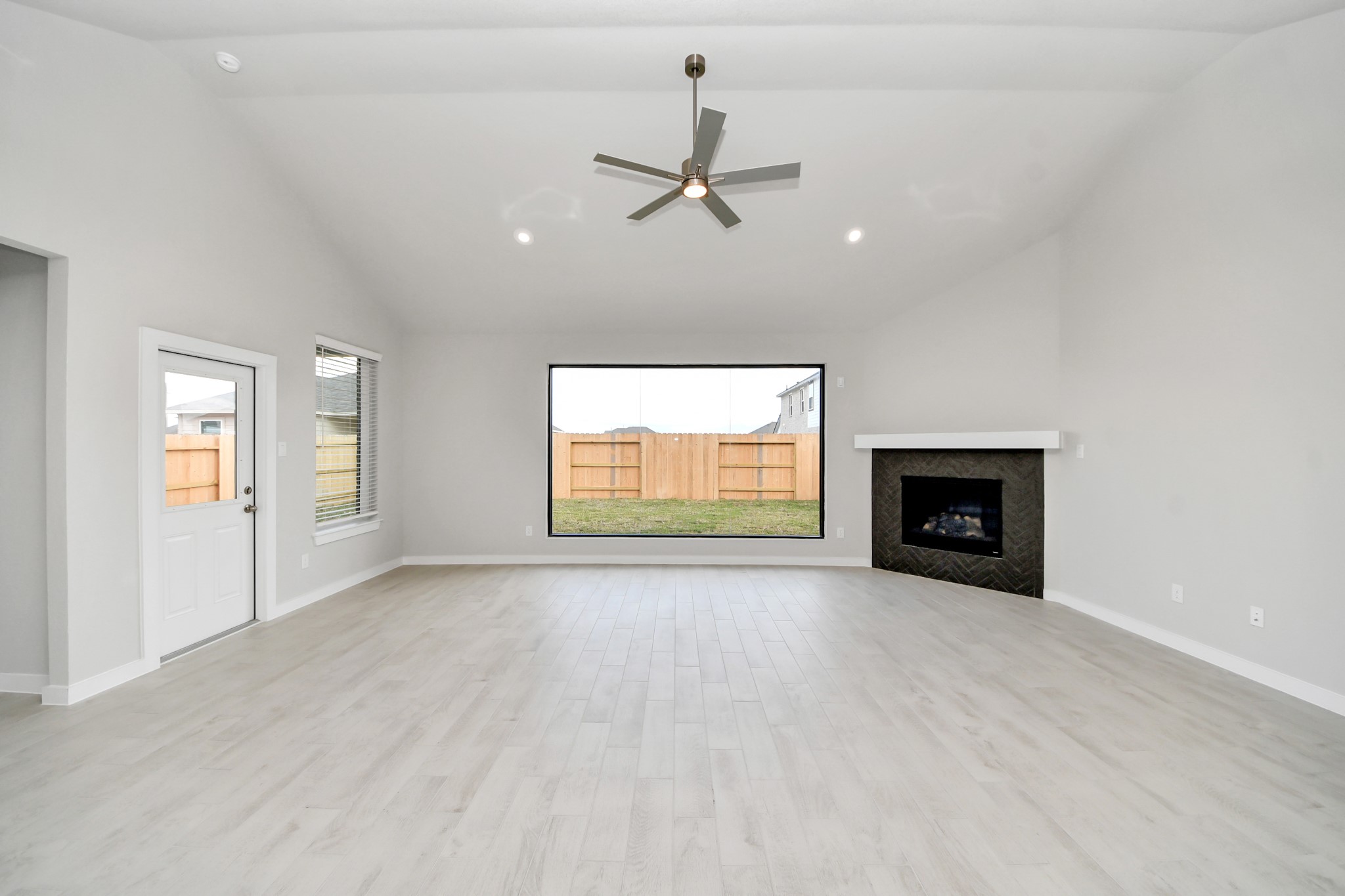 Gather the family and guests together in your lovely living room! Featuring soaring high ceilings, recessed lighting, ceiling fan, custom paint, gorgeous floors, and large windows that provide plenty of natural lighting throughout the day. Sample photo of completed home with similar floor plan. Actual colors and selections may vary.