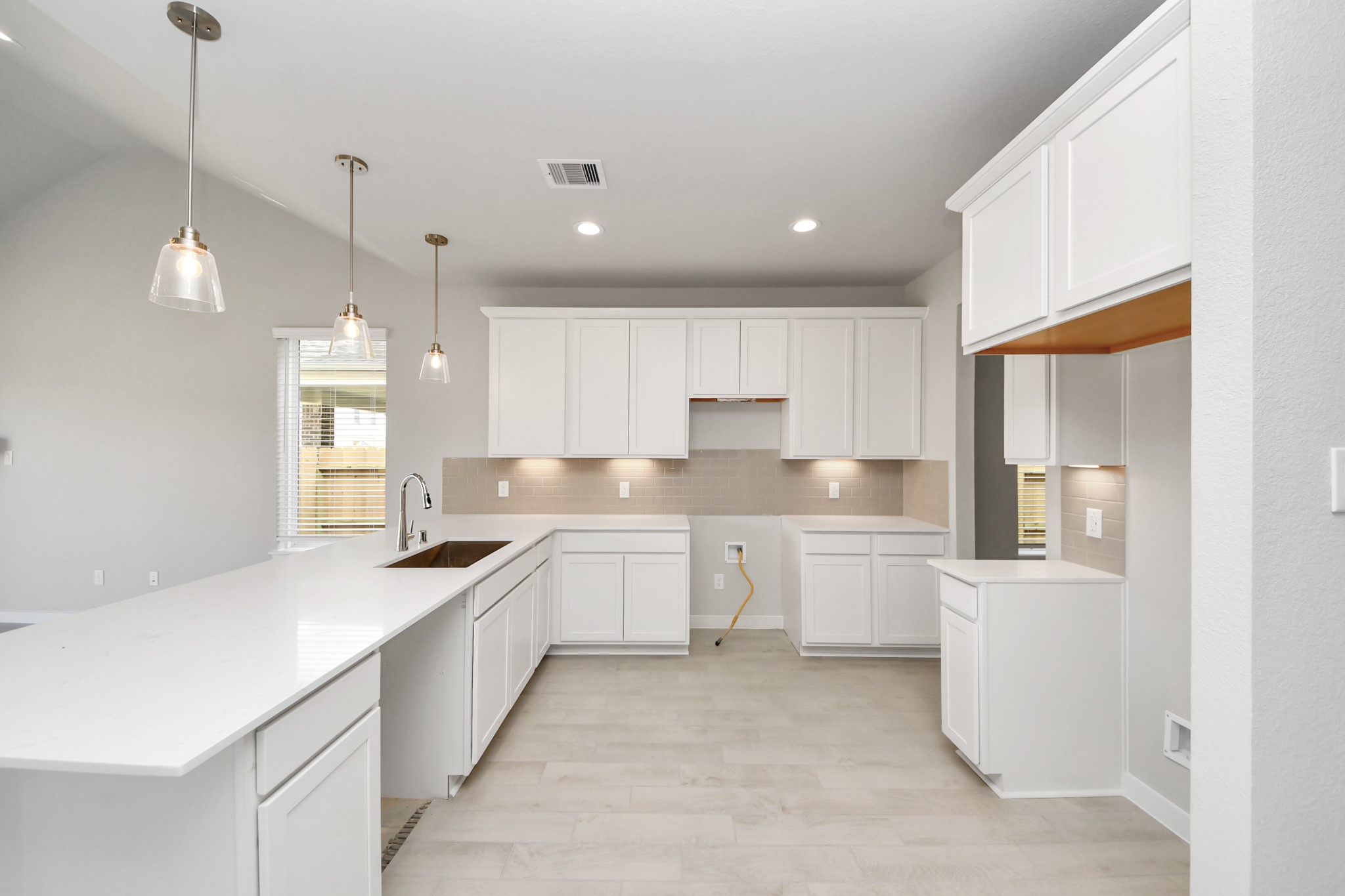 The kitchen is a culinary haven, featuring granite countertops, a tile backsplash, stainless steel appliances, 42 upper cabinets, and undercabinet lighting. Sample photo of completed home with similar floor plan. Actual colors and selections may vary.
