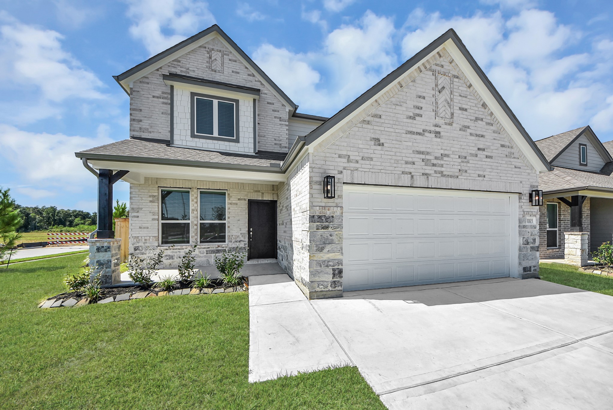 The residence features a practical 2-car garage complemented by a generous driveway, ensuring abundant space for parking needs.