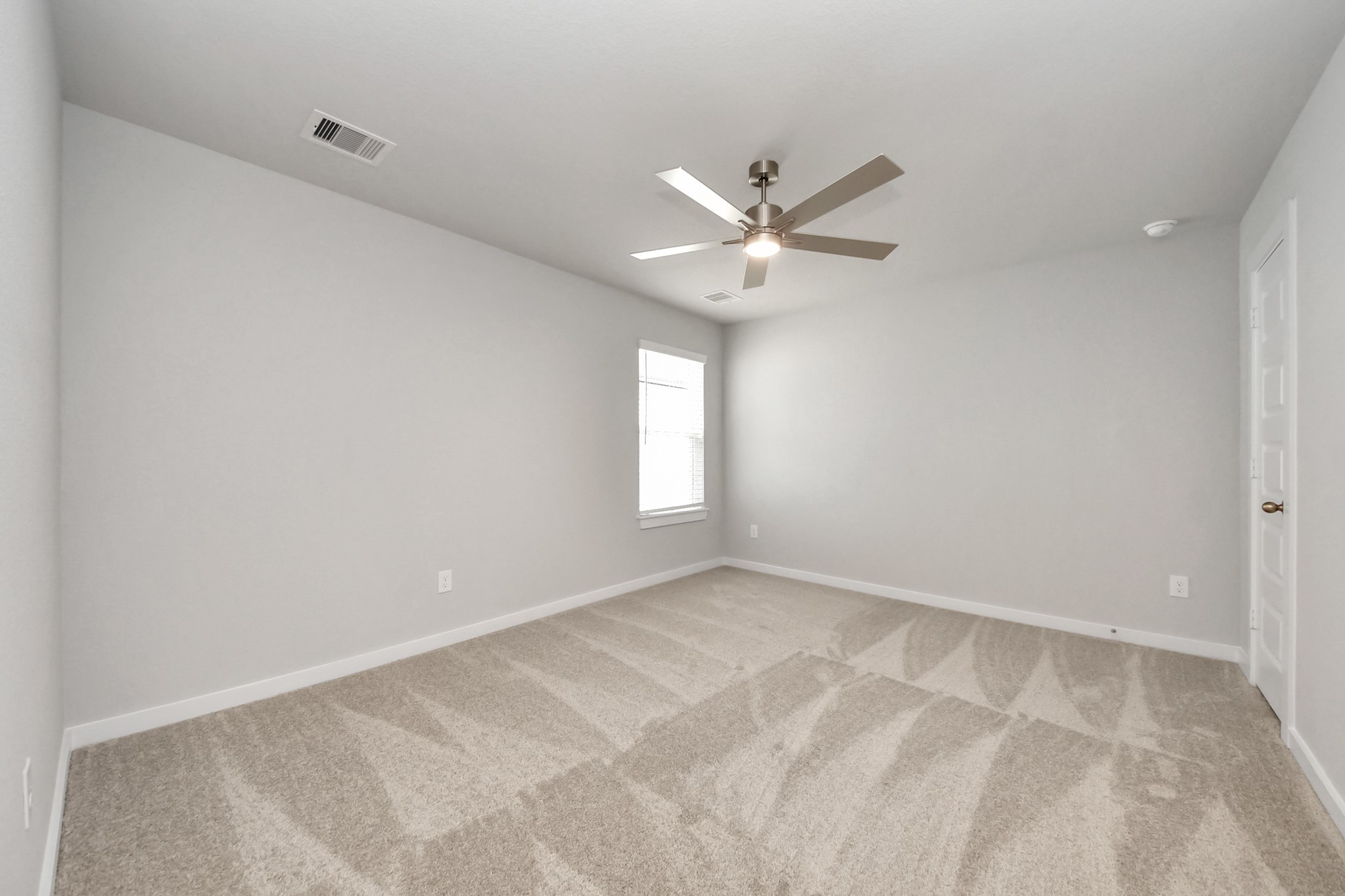Secondary bedroom features plush carpeting, large windows that let in plenty of natural light, bright paint, and spacious closets. Sample photo of completed home with similar floor plan. Actual colors and selections may vary.