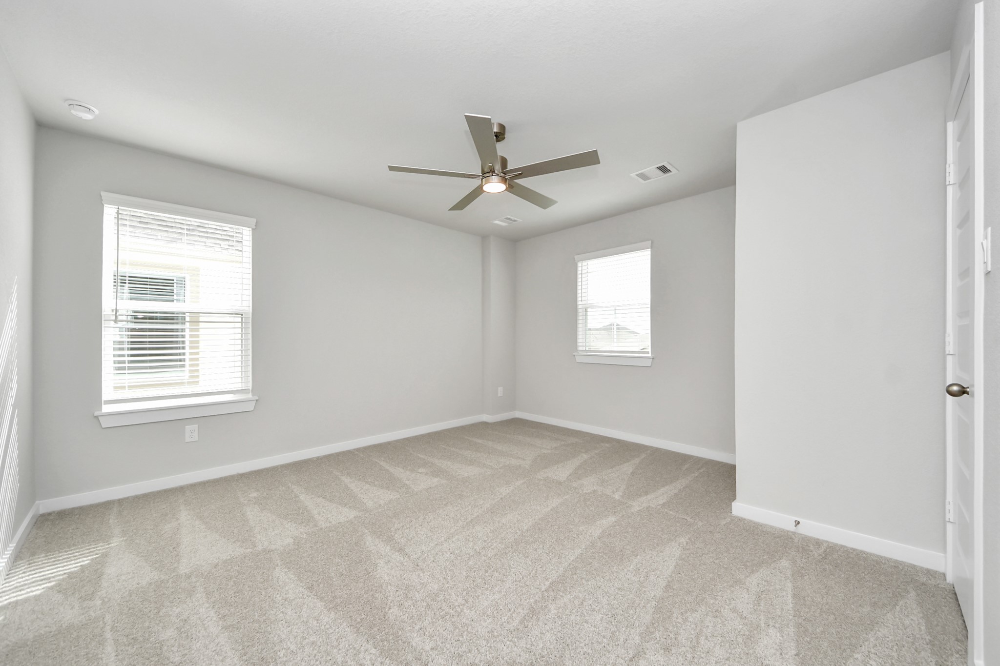 Secondary bedroom features plush carpeting, large windows that let in plenty of natural light, bright paint, and spacious closets. Sample photo of completed home with similar floor plan. Actual colors and selections may vary.