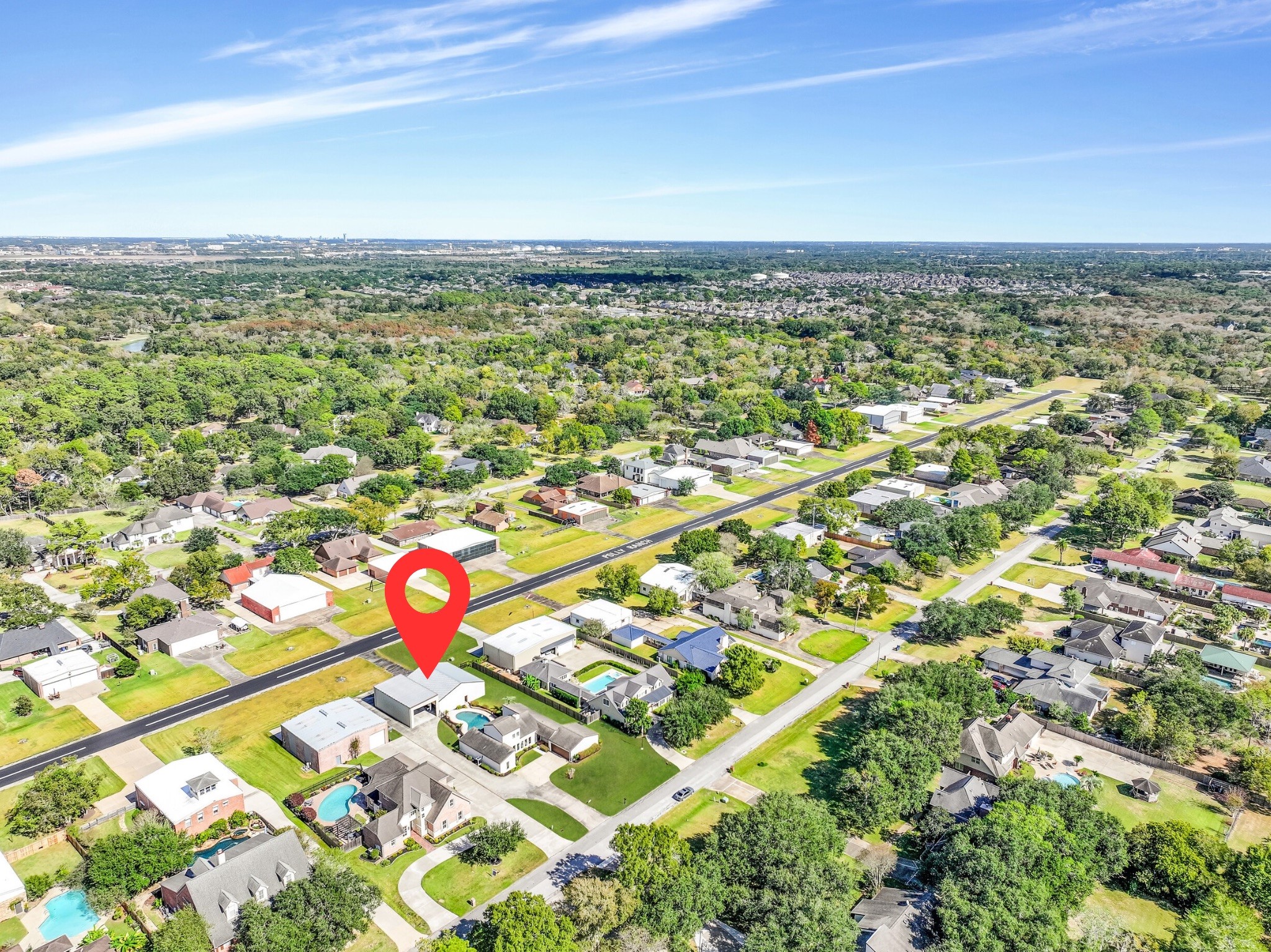 An incredible aerial perspective of Polly Ranch Estates highlights this property's exceptional location directly along the community airstrip. The marked property features a private airplane hangar, adjoining RV garage, backyard swimming pool, and direct taxiway access to the 3,070' runwayall in the heart of Friendswood!