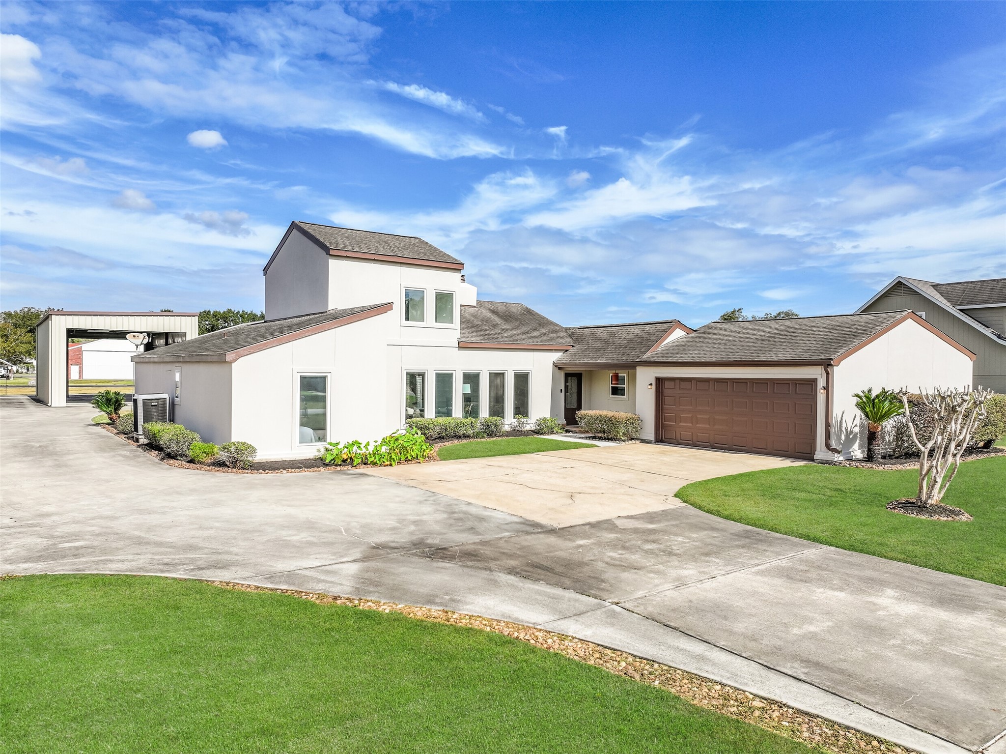 This distinctive home offers approximately 2,250 square feet with 3 bedrooms, 2 bathrooms & an attached 2-car garage. The contemporary-style exterior features varied rooflines, a wall of windows & manicured landscaping, while a separate driveway leads to the private hangar & RV garage.