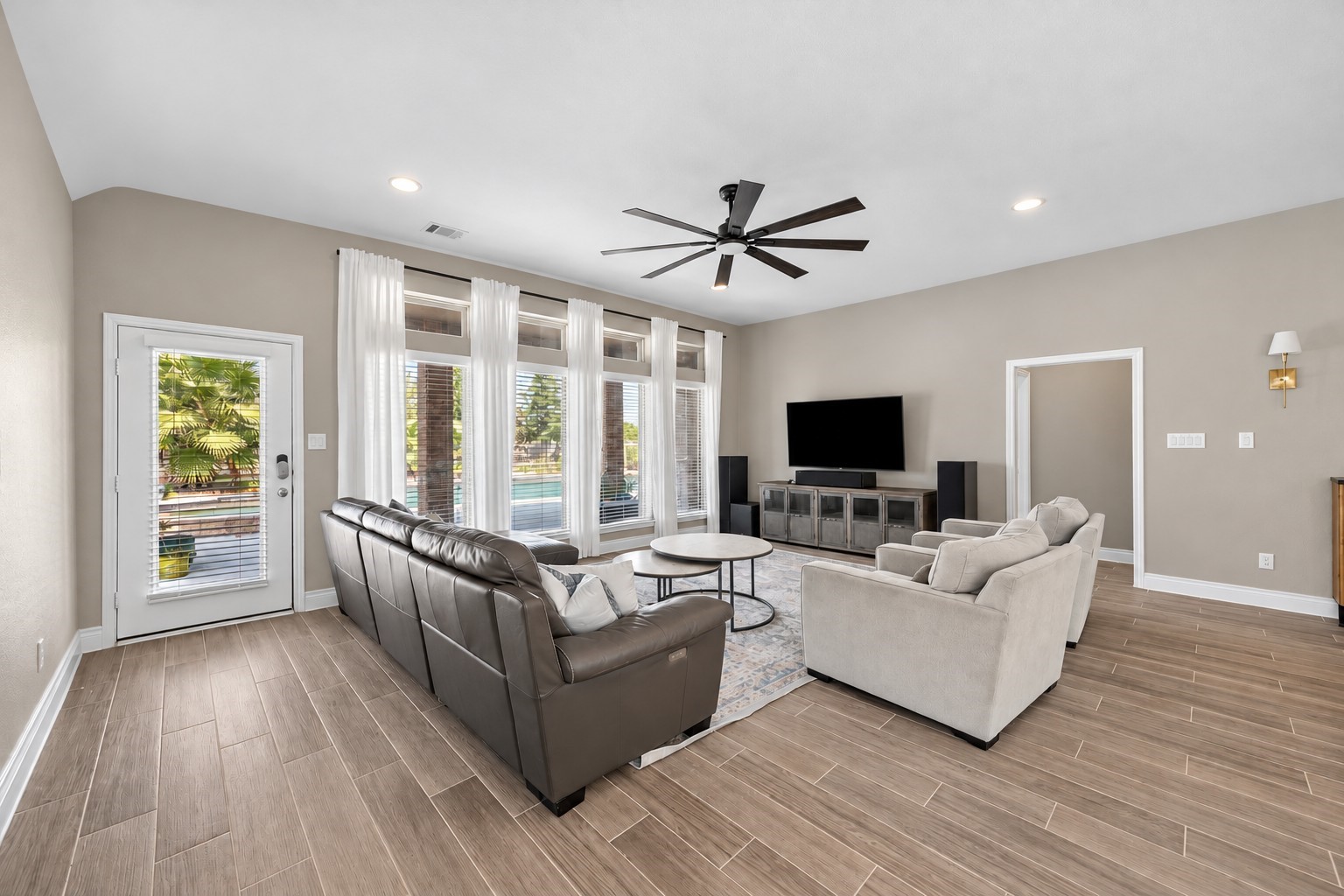 Open living room boasts wood look tile perfect for entry from the pool, pets, children, or just daily living!
