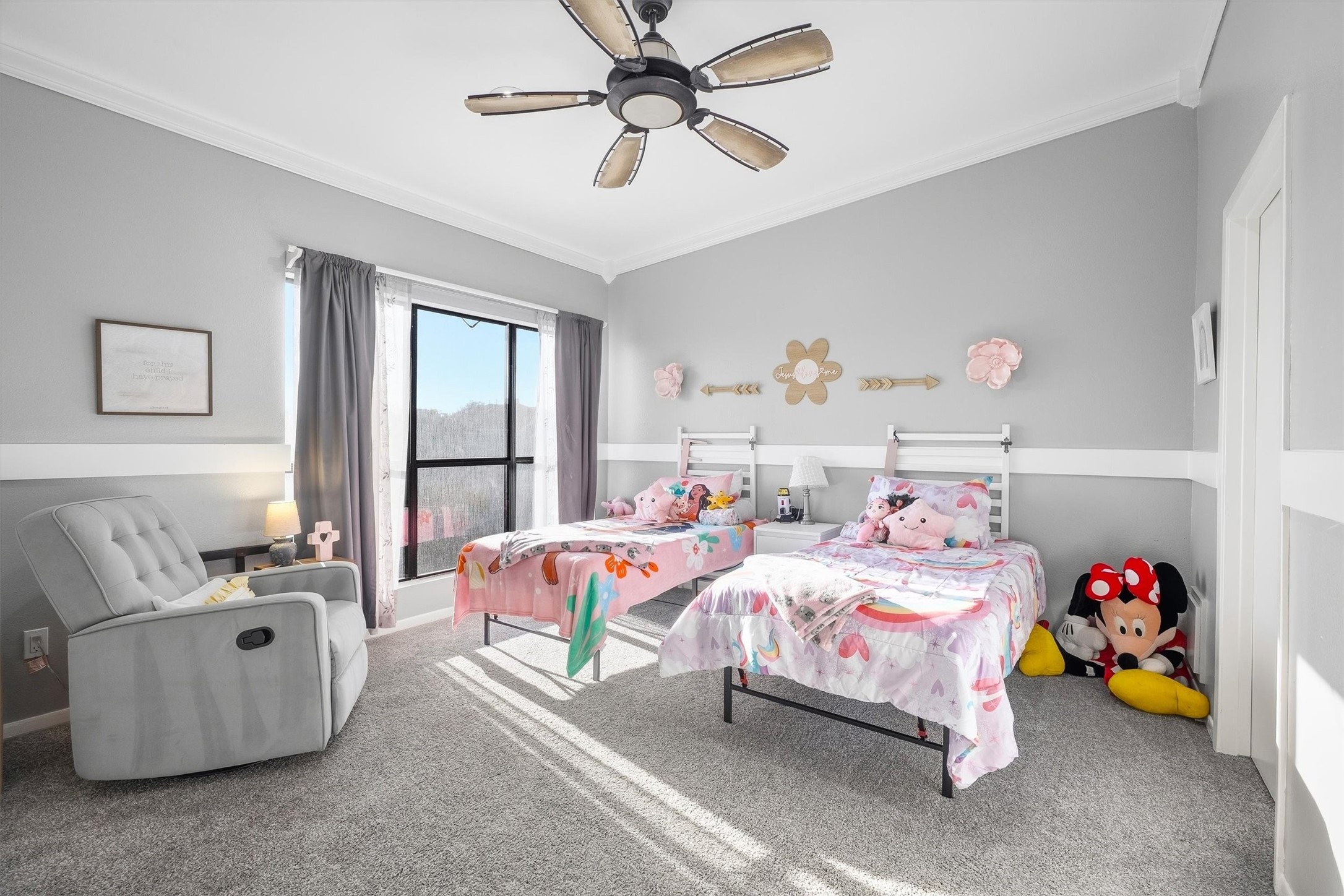 Secondary bedroom featuring large windows and a ceiling fan.