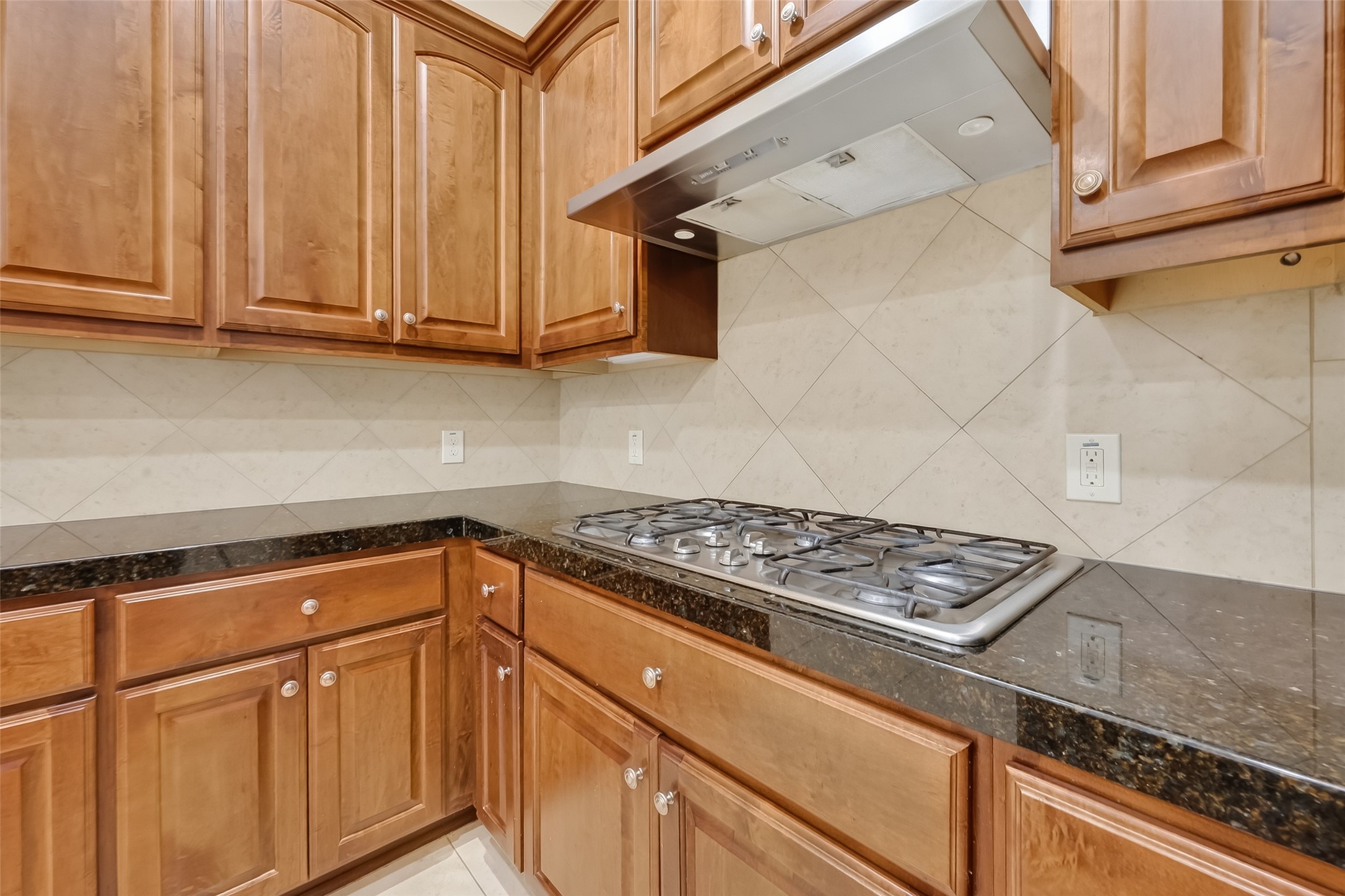 Gas Cook Top with 6 burners and stainless steel vent hood.