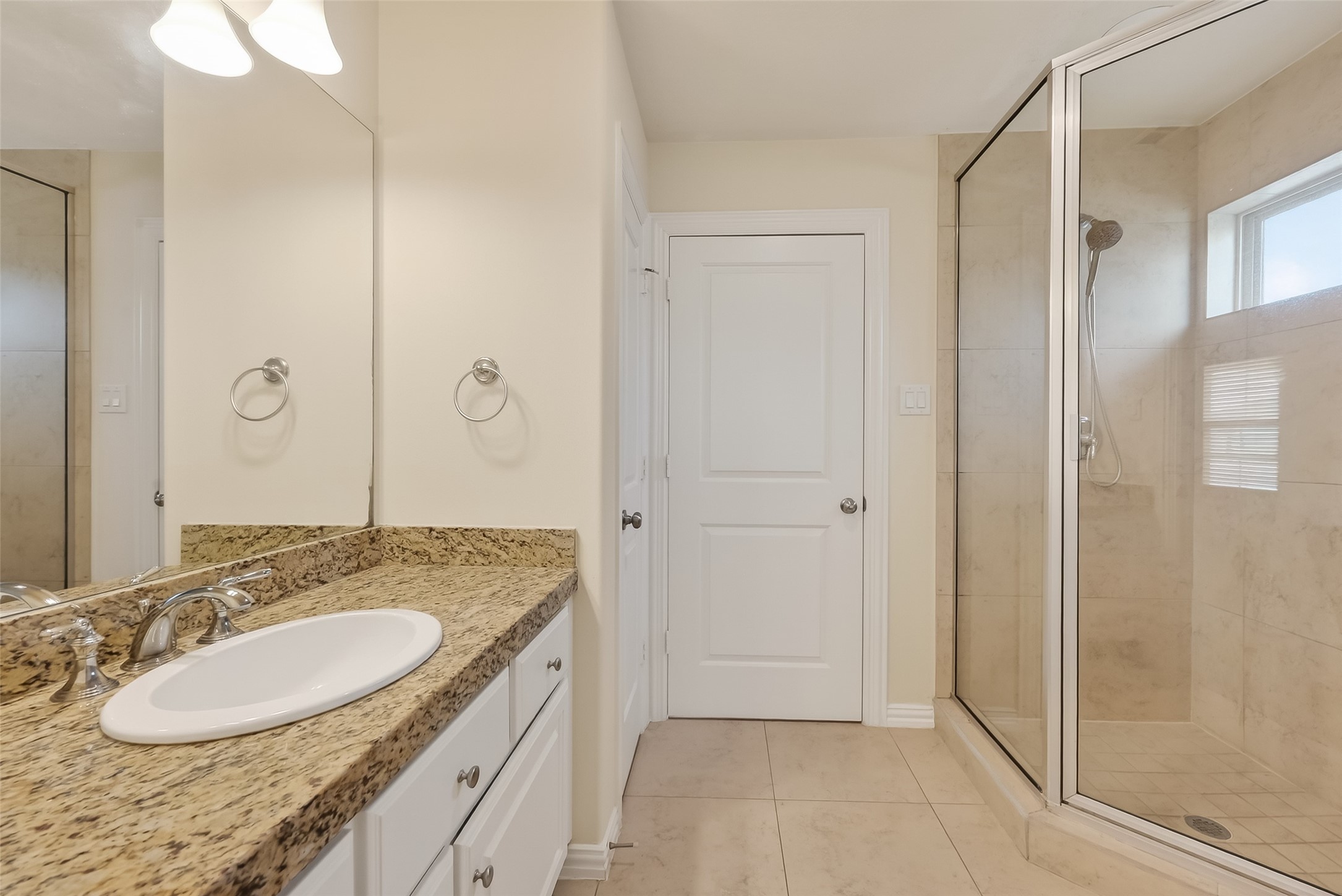 Bathroom of the fourth bedroom that opens to Game Room. Offers endless granite countertop, wall to wall mirror and a shower.