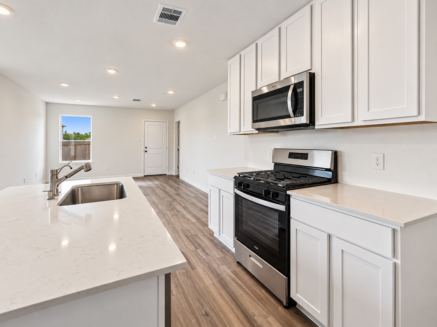 The kitchen is perfectly situated for preparing meals while still visiting with family and friends.