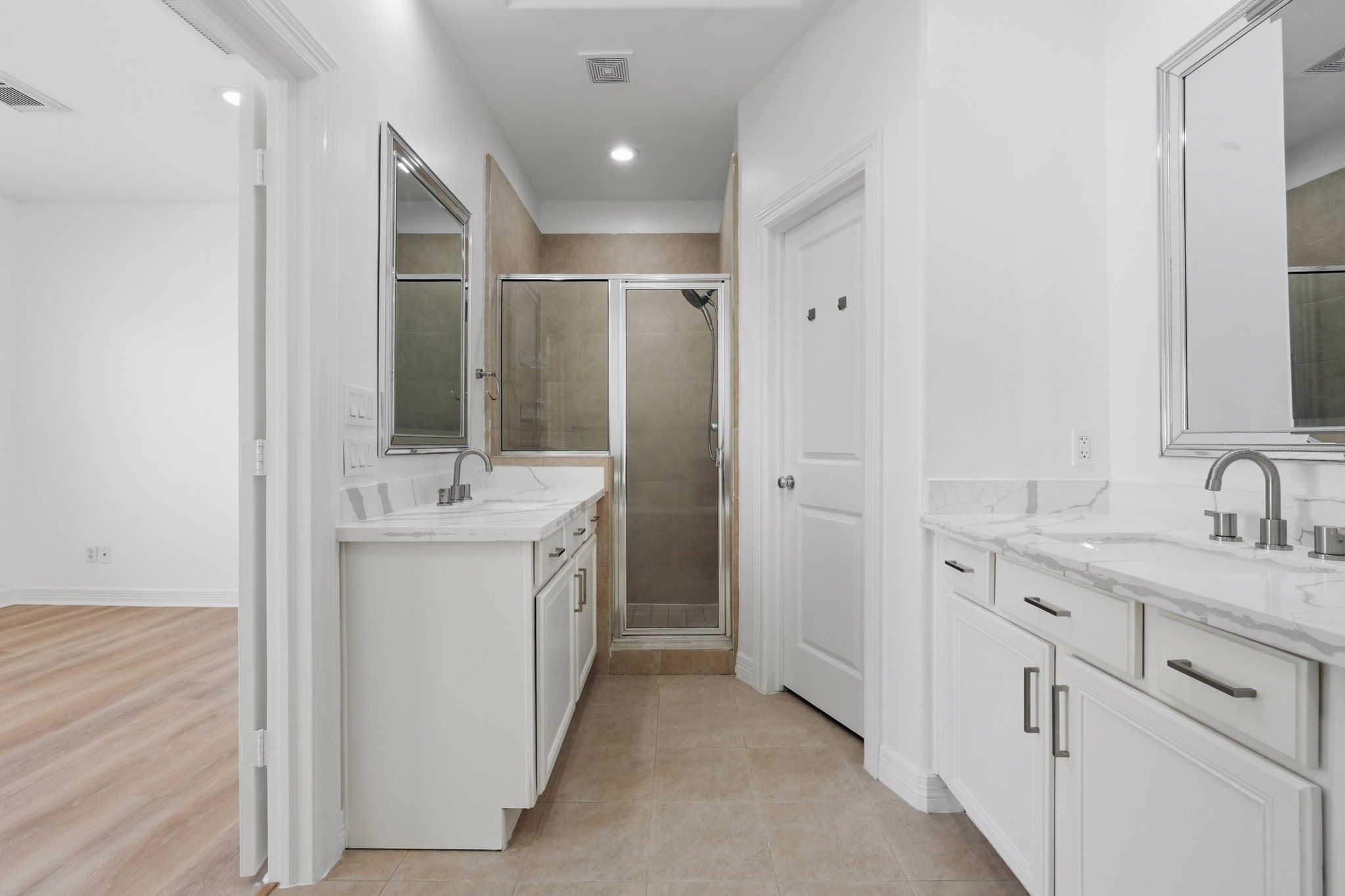 The primary bathroom highlights its functional layout, with separate vanity areas, generous cabinet storage, and a central walkway that allows for easy movement throughout the space. (3rd floor)