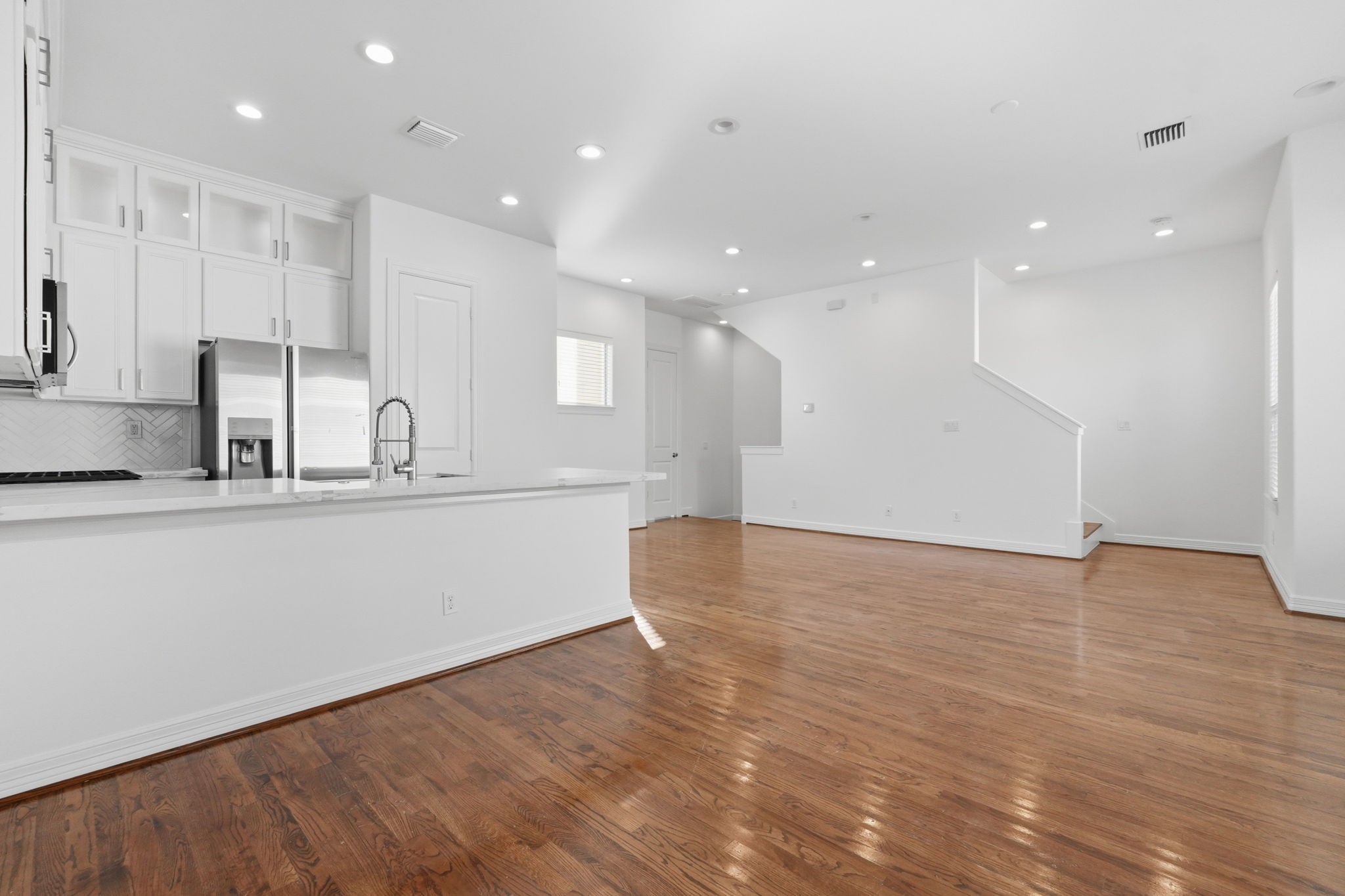 The kitchens breakfast bar overlooks the main living space, while recessed lighting, high ceilings, and an open floor plan create a seamless connection between the homes gathering areas. (2nd floor)
