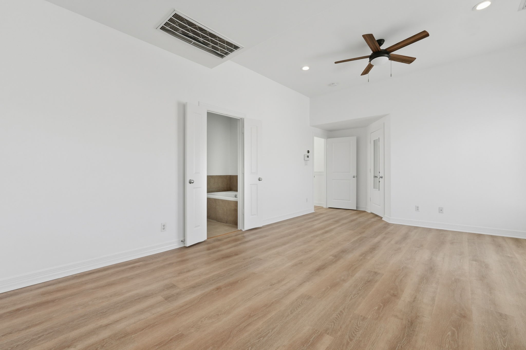 The primary bedroom offers another perspective of its generous layout, highlighting the vaulted ceiling and open wall space that allow for flexible room arrangements. (3rd floor)