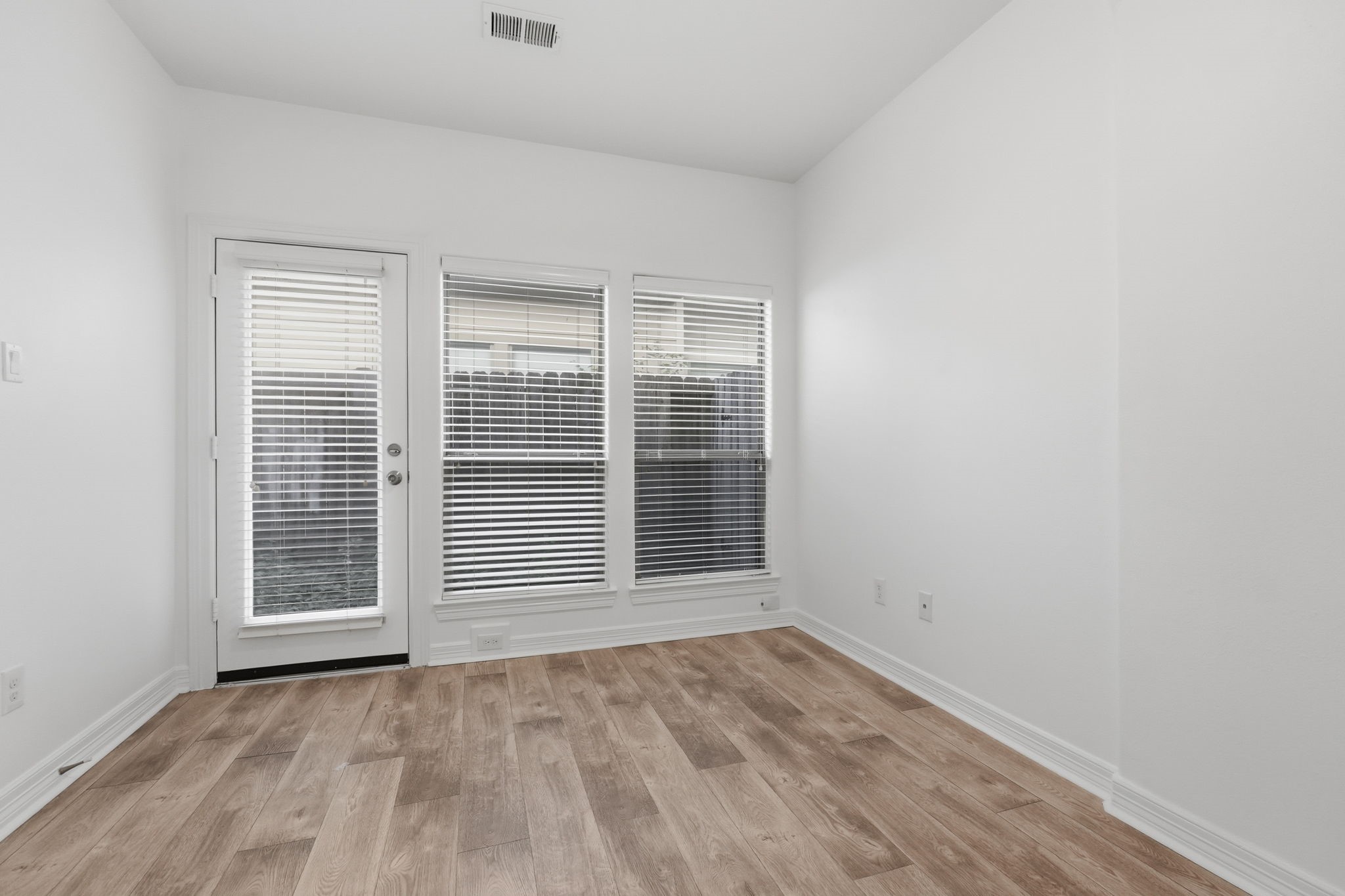 The secondary bedroom #1 features a clean, neutral palette, recessed lighting, and a wide set of windows that bring in natural light, offering a versatile space. (1st floor)