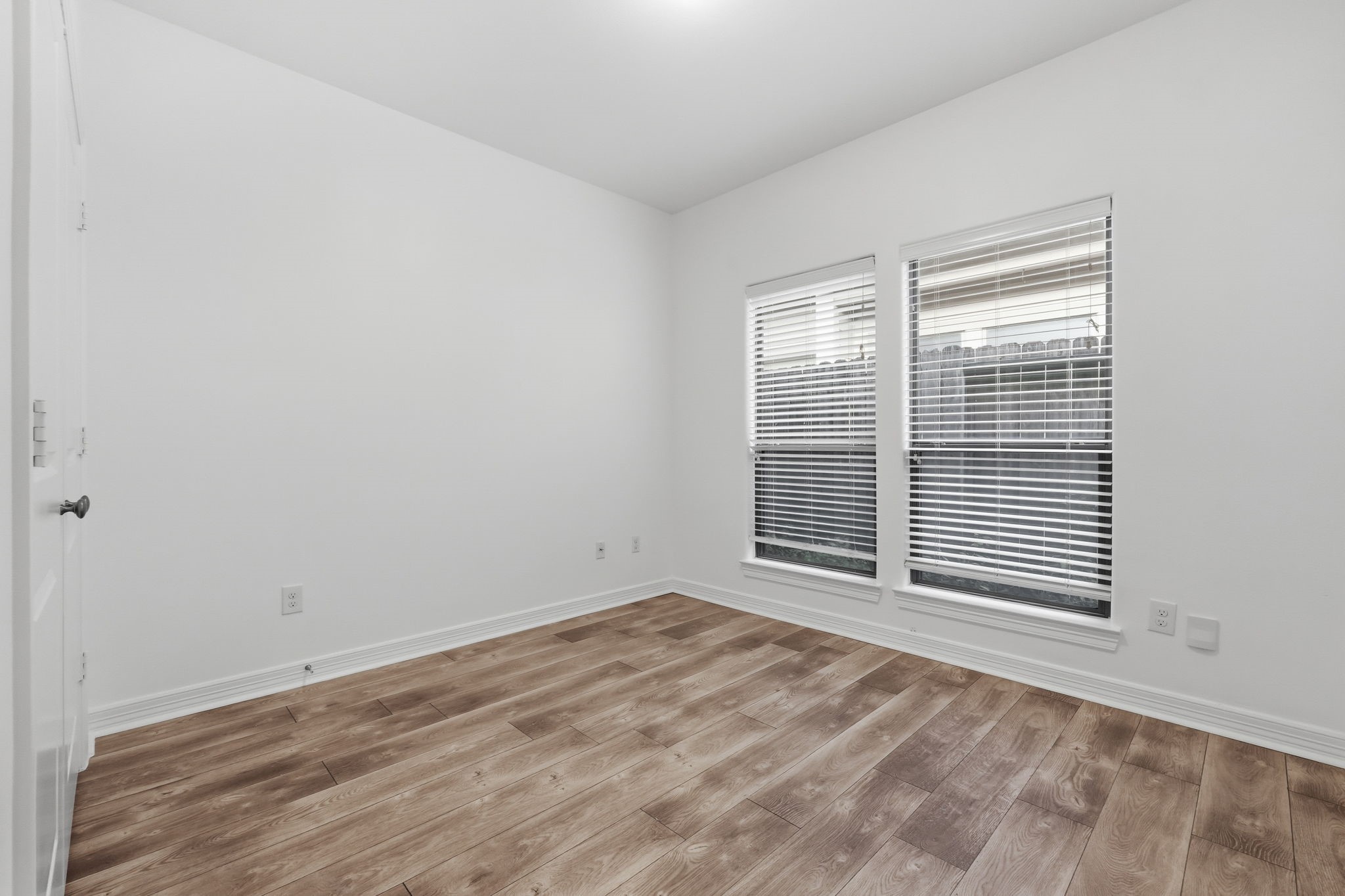 A well-proportioned secondary bedroom #2 features wide windows, and a neutral color palette, offering a flexible layout suited for a variety of needs. (1st floor)